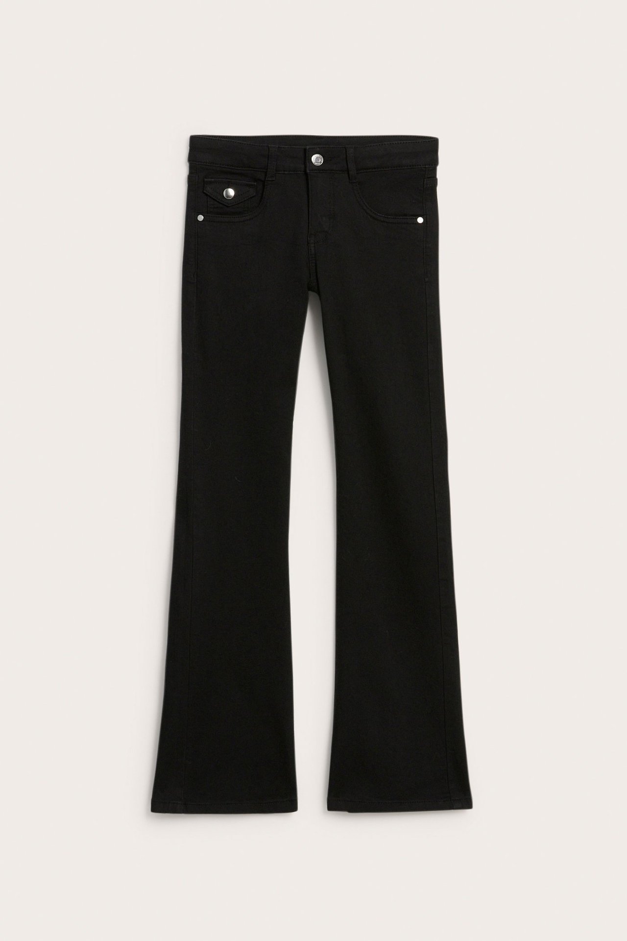 Edestä: mustat bootcut-farkut matalalla vyötäröllä ja hopeisilla nappiyksityiskohdilla.