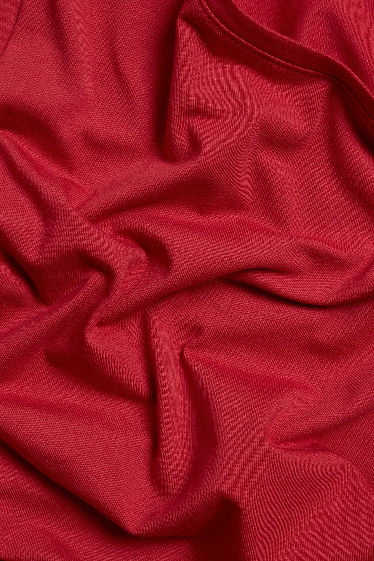 Zbliżenie czerwonego, krótkiego topu basic z okrągłym dekoltem, z prążkowanej mieszanki bawełny.