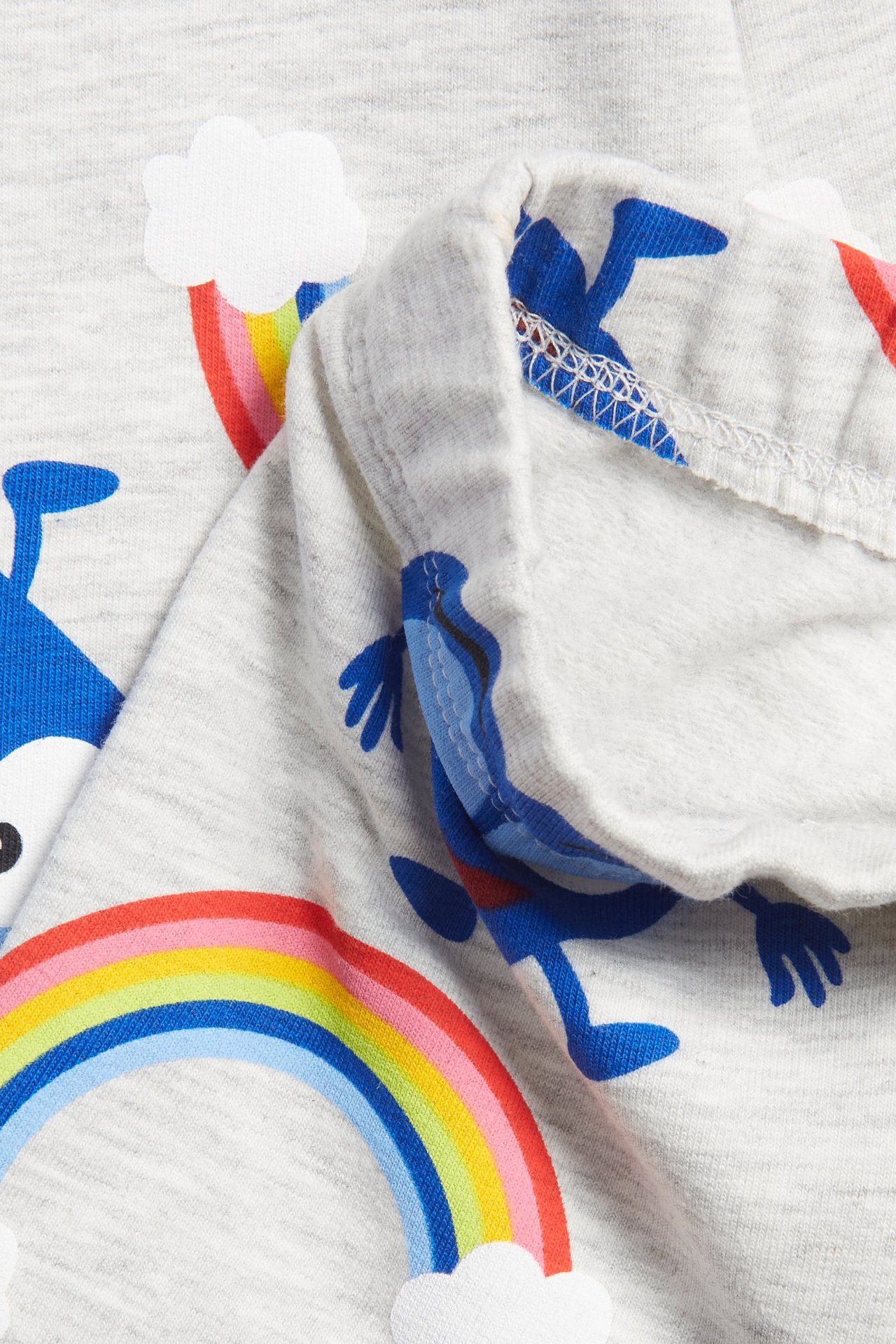 Närbild av ljusgrå baby leggings med färgglada Babblarna-figurer och regnbågsmönster.