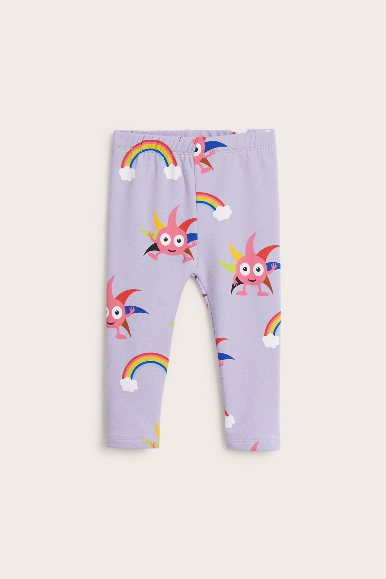 Frontvy av babyens ljuslila mönstrade leggings med Babblarna-figurer och regnbågar, i bomullsblandning.
