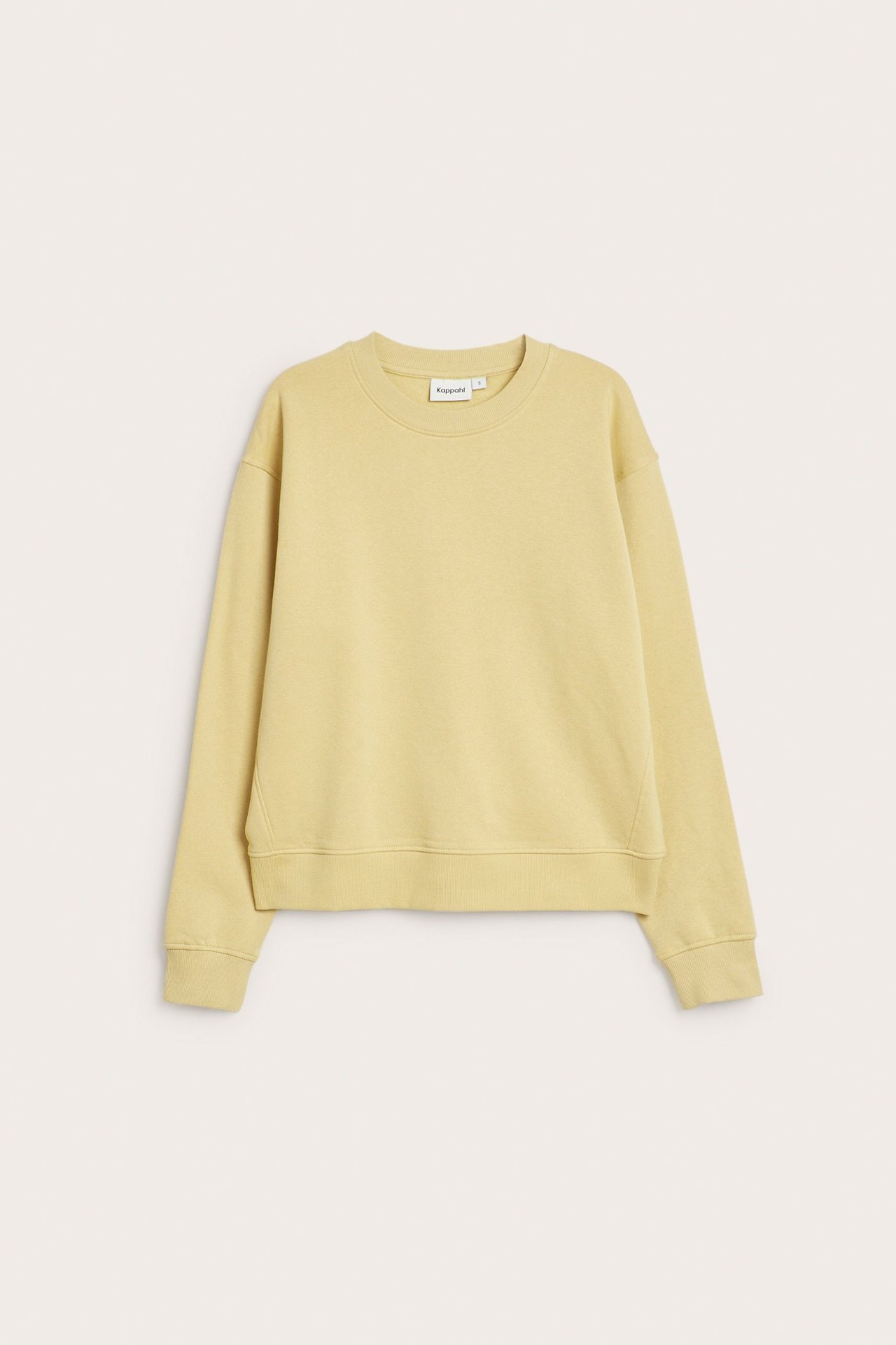 Widok z przodu jasnożółtej, jednokolorowej bluzy z okrągłym dekoltem, długimi rękawami i ściągaczami.