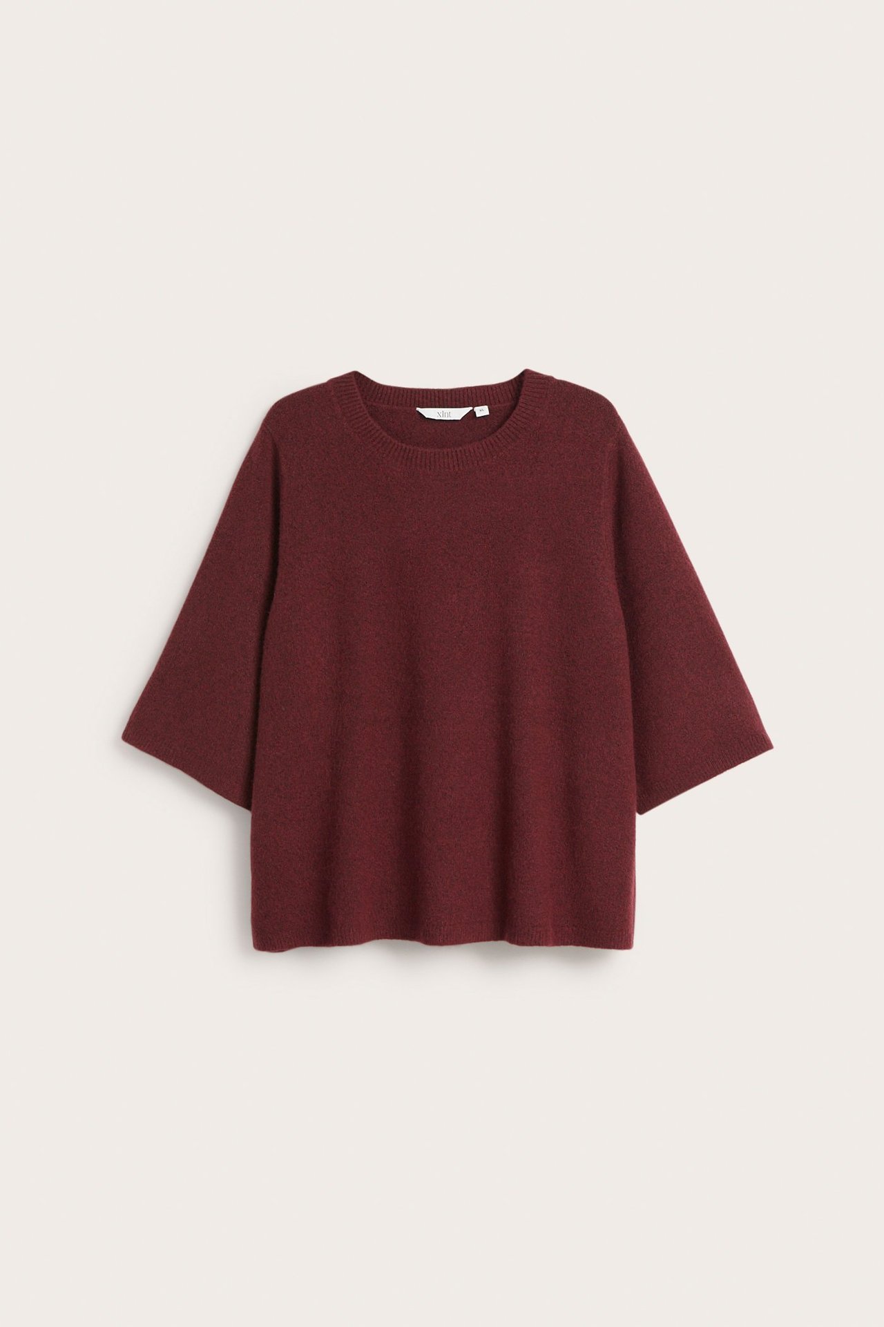 Edestä näkymä meleeratusta viininpunaisesta neulepaidasta, jossa pyöreä kaula-aukko ja leveät 3/4-hihat.