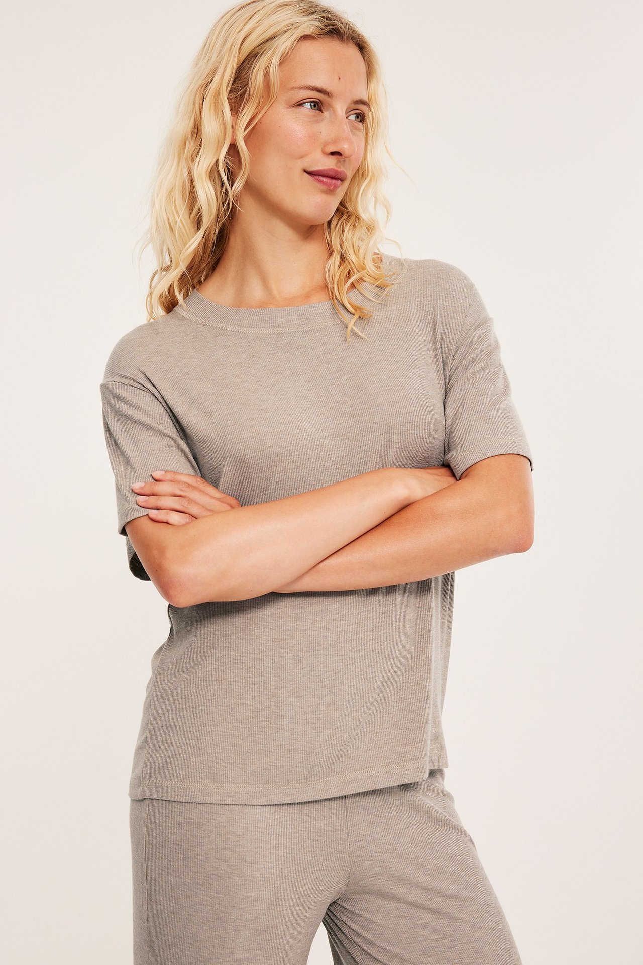 Naisen etukuva: beige melange -värinen ribattu pyjamatoppi ja yhteensopivat housut.