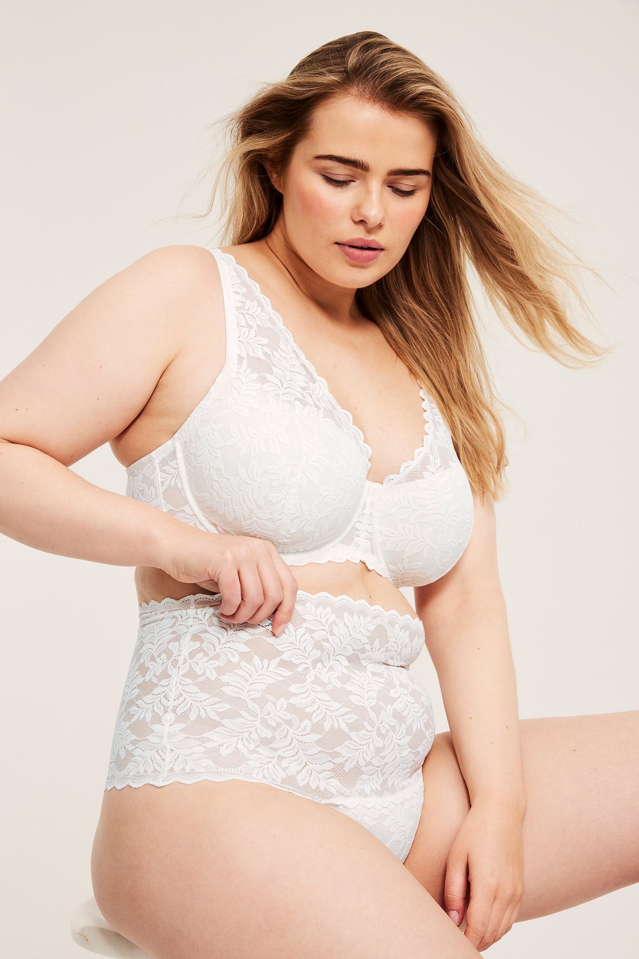 Framifrån, kvinna i offwhite hög midja spetstrosa och matchande spetsbehå.