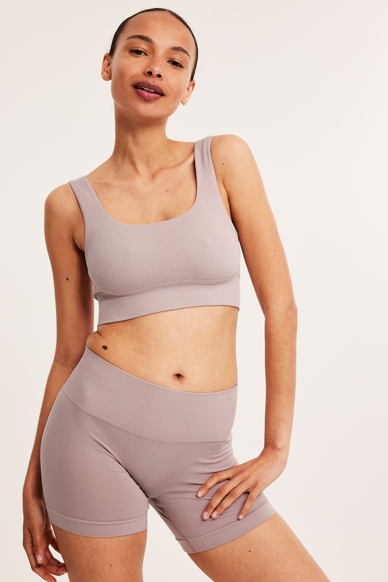 Frontbilde av kvinne i rosa bomullsmiks-shorts med ribbet midje og matchende sports-bh.