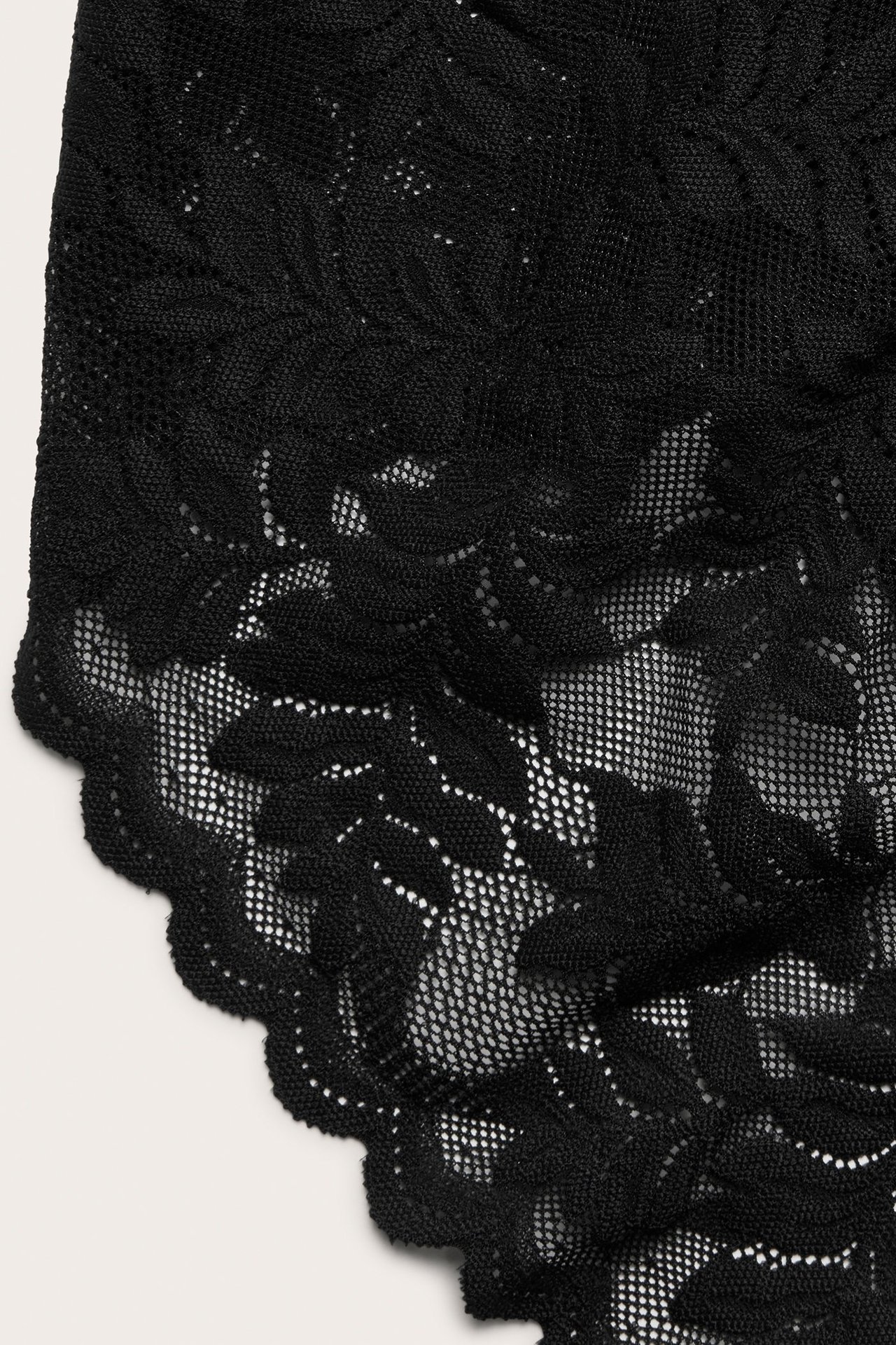 Zbliżenie czarnych koronkowych fig z kwiatowym wzorem.