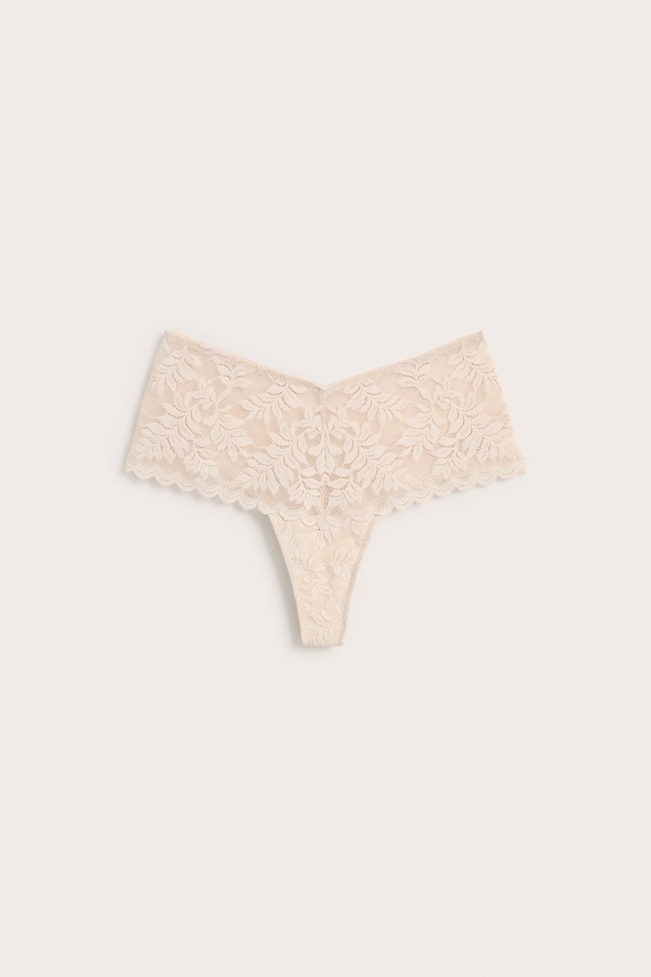 Forfra av en beige blondetruse med blomstermønster.
