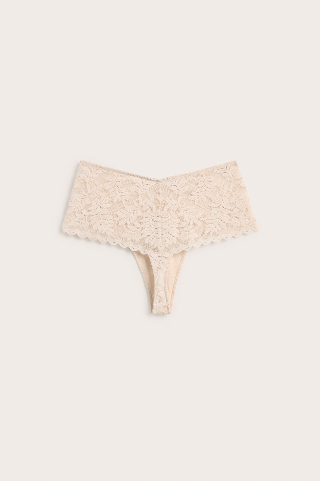 Framifrån, beige spetstrosa med blommönster.