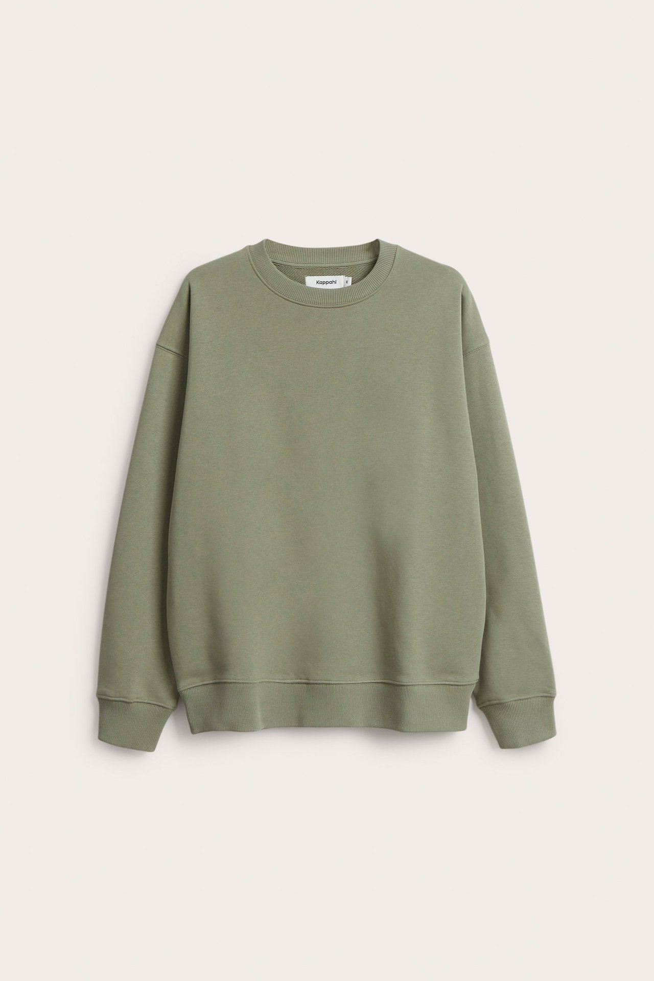 Mężczyzna w zielonej oversize melanżowej bluzy z opuszczonym ramieniem, przód.