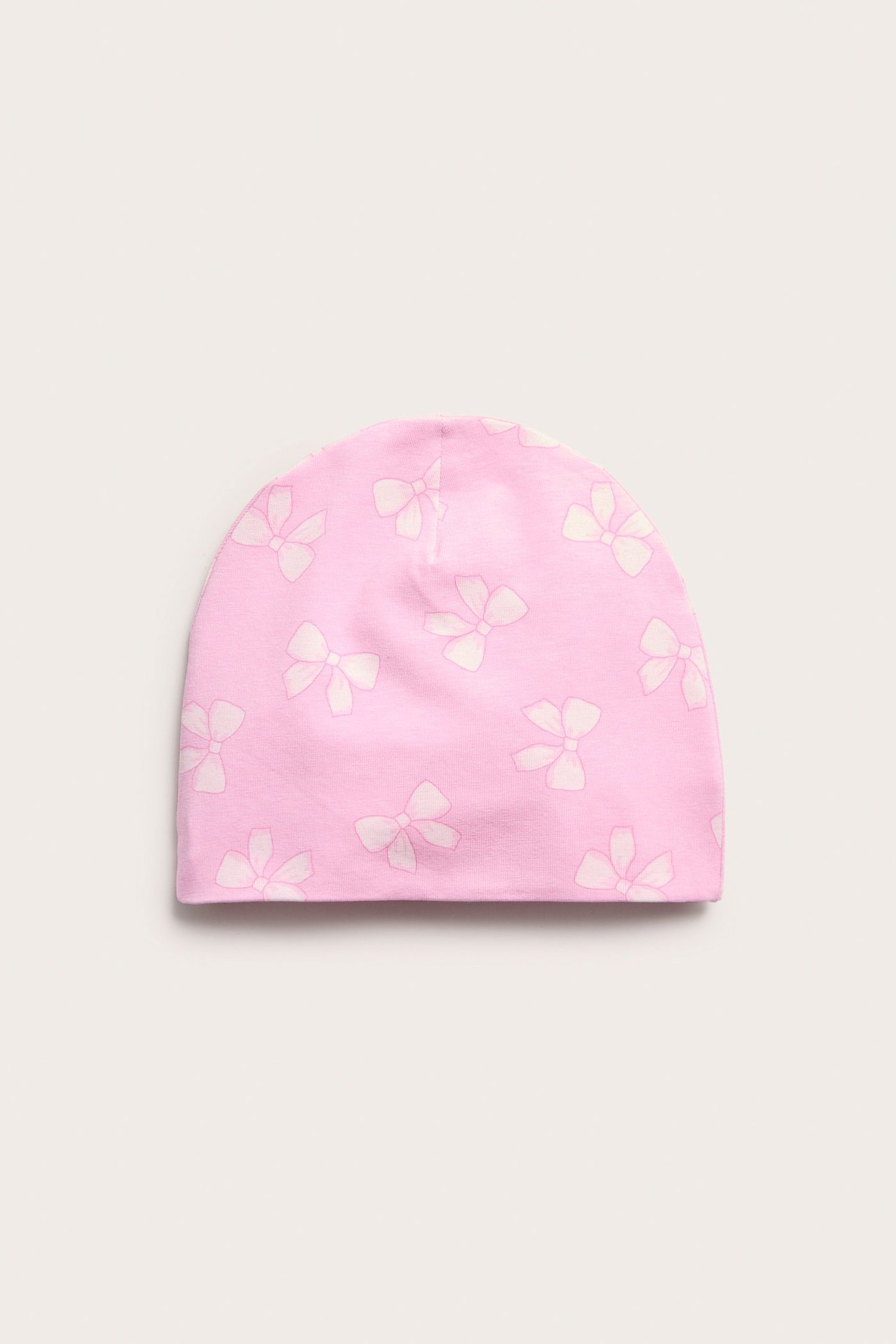 Edestä, vaaleanpunainen jerseymyssy valkoisella rusettikuviolla.