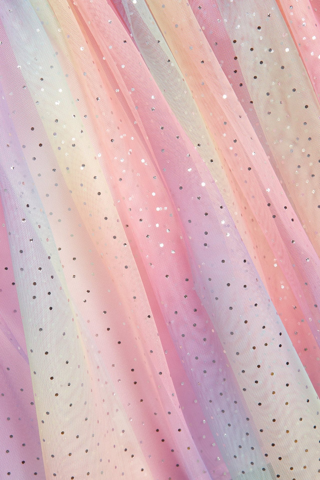 Zbliżenie tęczowej spódnicy tiulowej ze srebrnym brokatem.