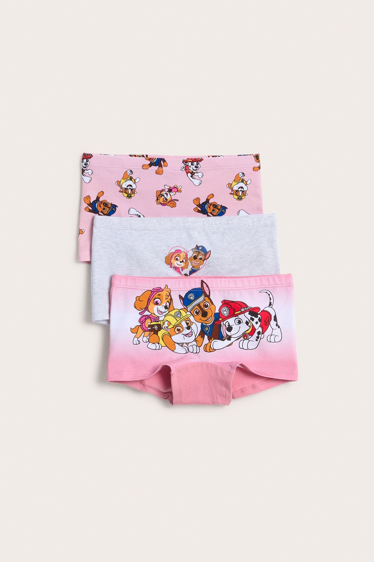Edestä näkymä kolmesta lasten puuvillaisesta Paw Patrol -bokserista vaaleanpunaisena ja vaaleanharmaana.
