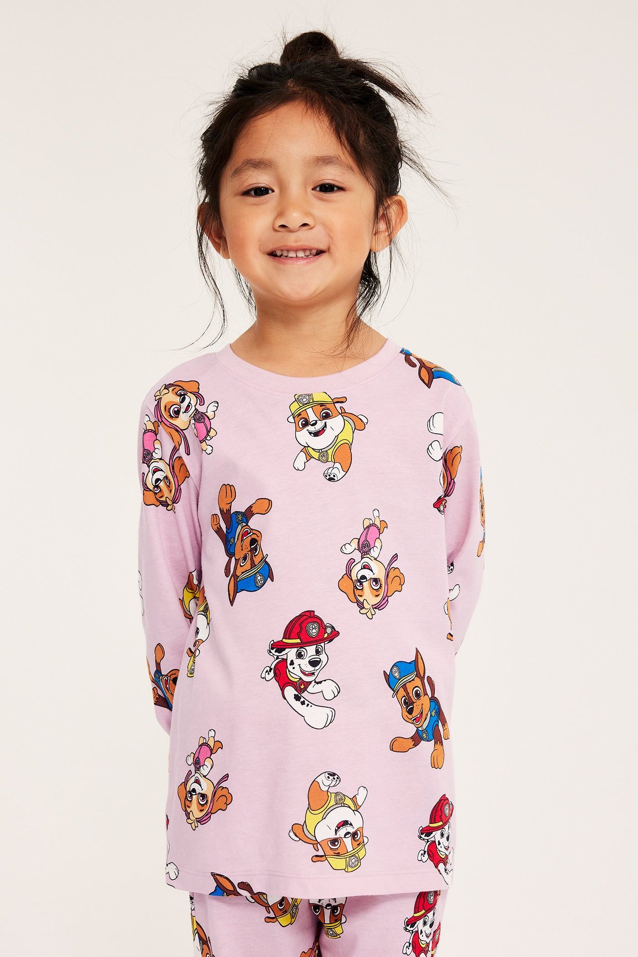 Tyttö vaaleanpunaisissa Paw Patrol -pyjamasissa, pitkähihaisessa, puuvillainen, kuvioitu edestä.