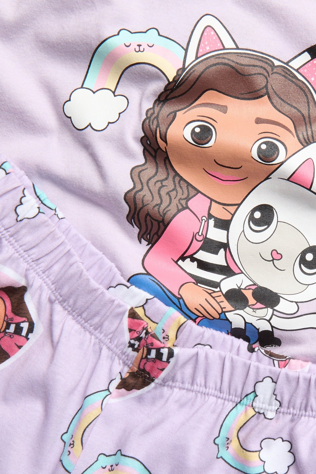 Zbliżenie na jasnofioletową bawełnianą piżamę dziecięcą z nadrukiem Gabby's Dollhouse i elastyczną talią.