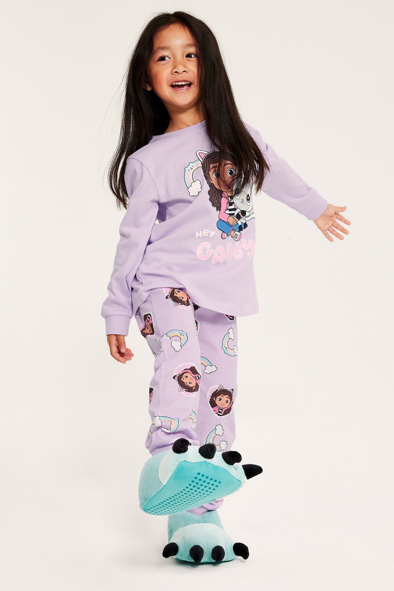 Dziewczynka w jasnofioletowej piżamie z motywem Gabby's dollhouse, widok z przodu.