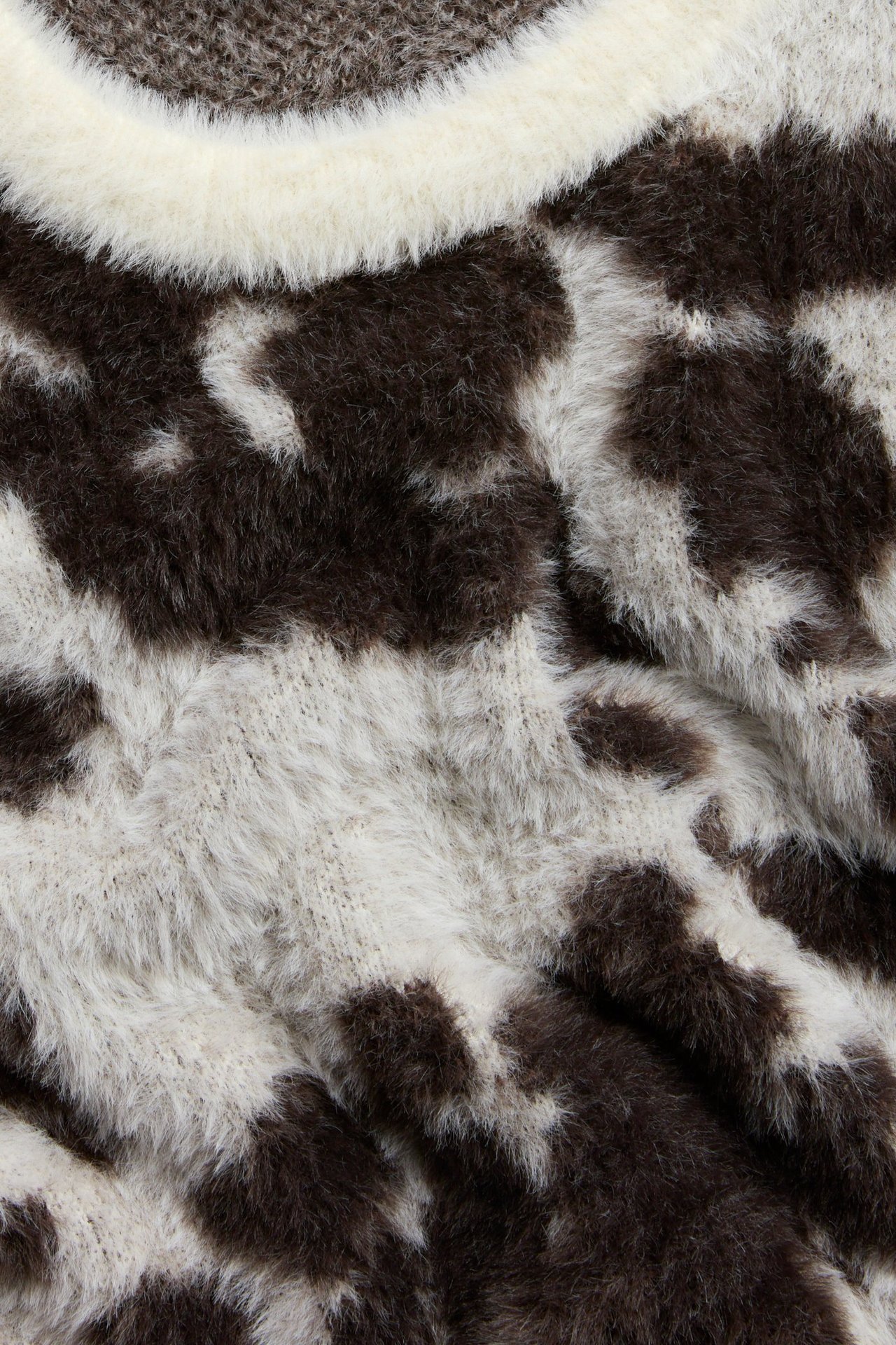 Zbliżenie na off-white i ciemnobrązowy, żakardowy, puszysty T-shirt z dzianiny.