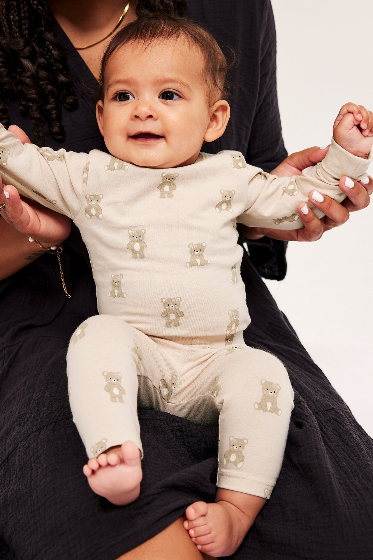 Edestä, vauva yllään vaaleanpunainen pitkähihainen body ja yhteensopivat leggingsit ruskealla nallekuviolla.