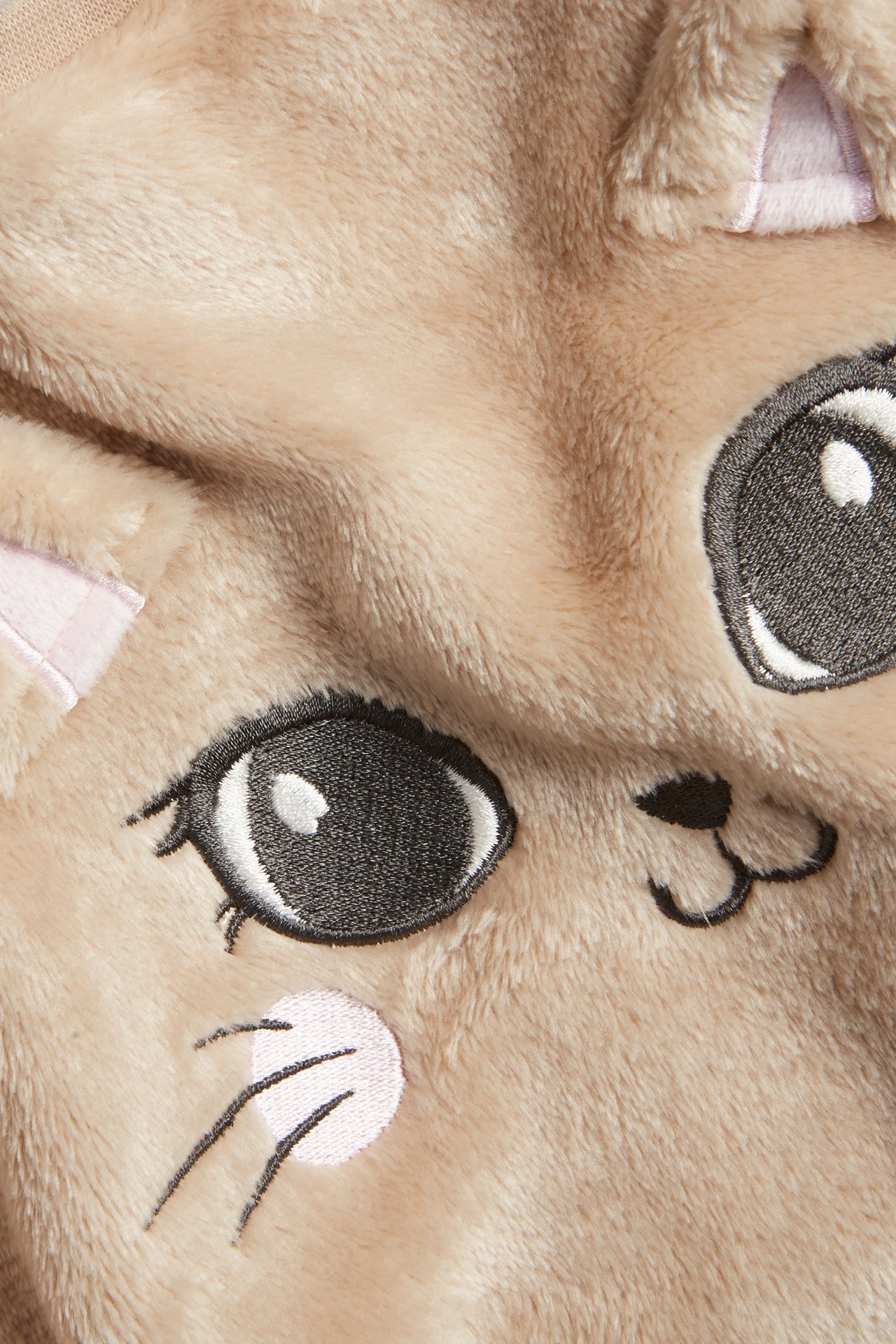 Zbliżenie z przodu beżowego puszystego swetra dziecięcego z poliestru z haftowaną aplikacją kota.