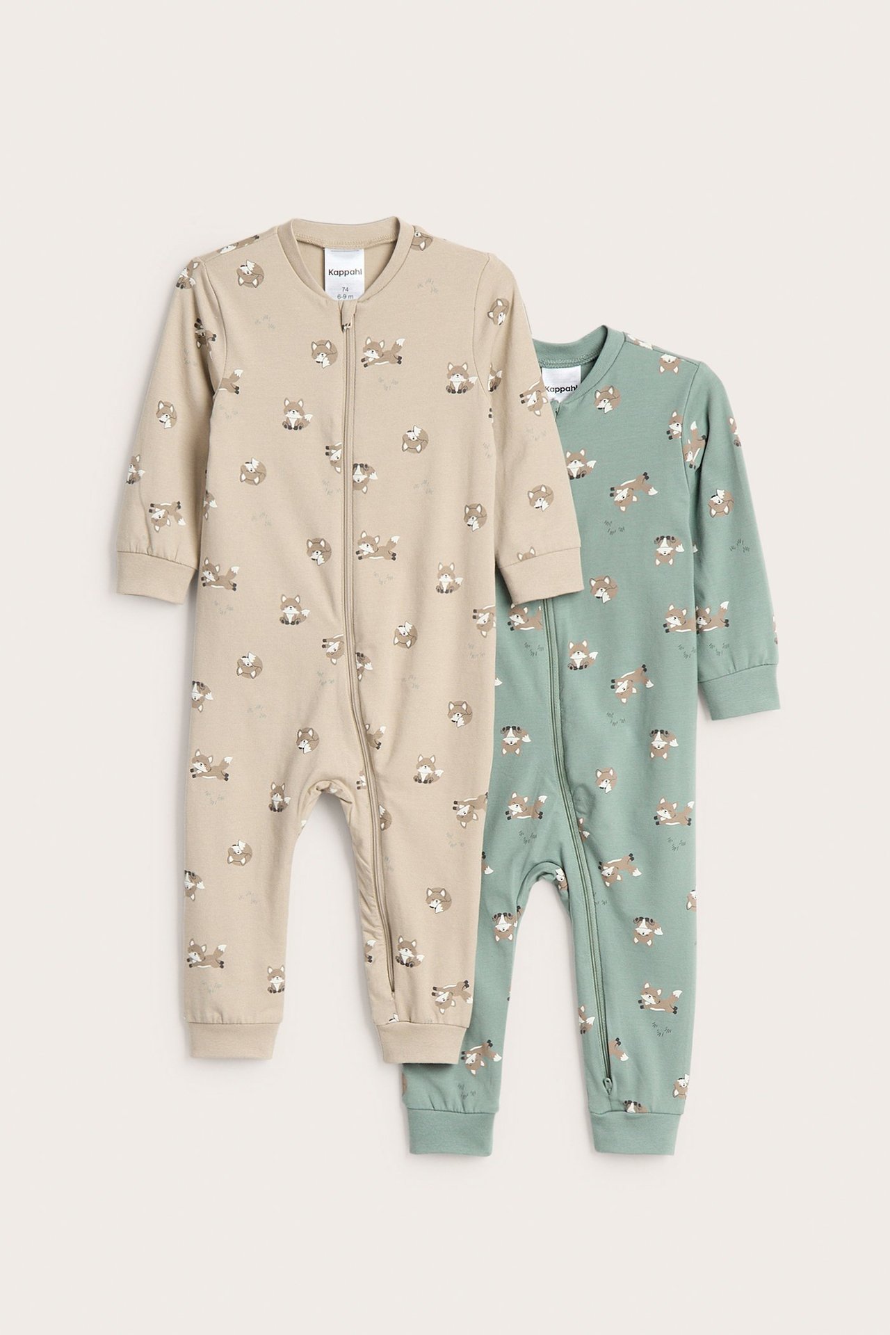 Etunäkymä kahdesta vauvan potkupuvusta: beigestä ja vihreästä, molemmissa eläinkuvio ja kaksisuuntainen vetoketju.