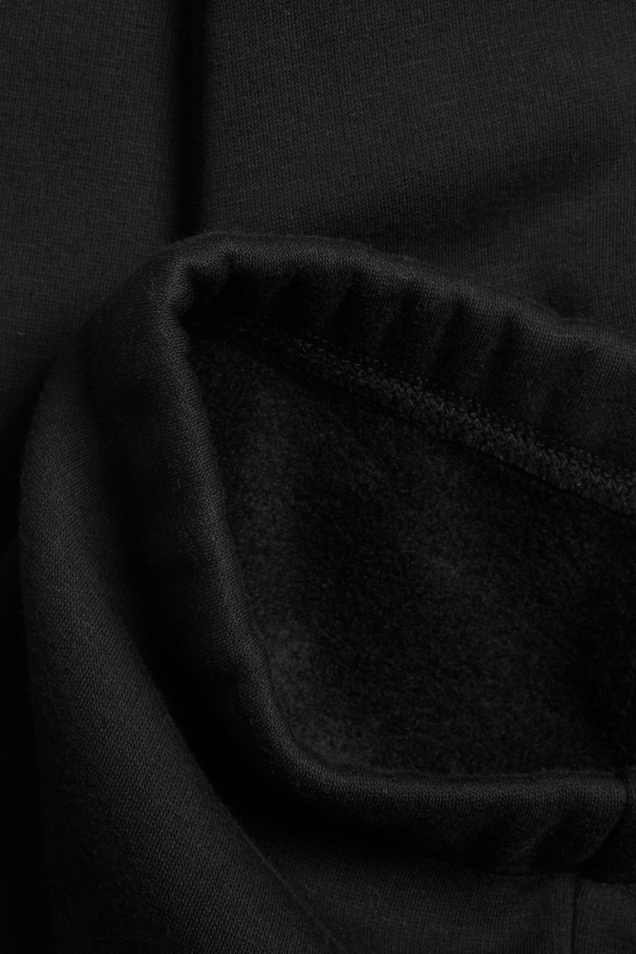 Zbliżenie czarnych legginsów flare, ukazujące miękki, szczotkowany materiał od wewnątrz.