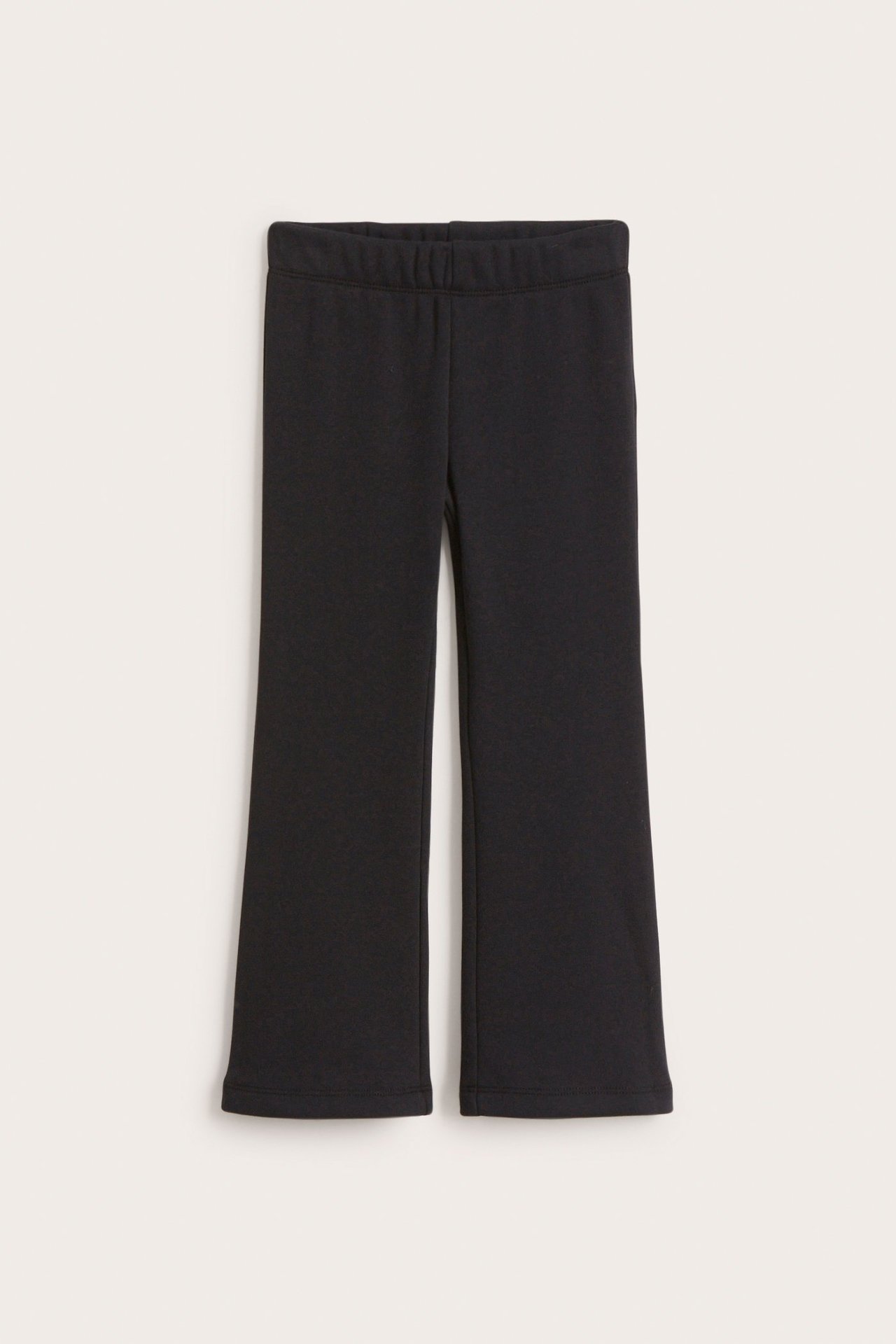 Edestä näkymä mustista lasten levenevistä leggingseistä joustavalla vyötäröllä, litteänä.