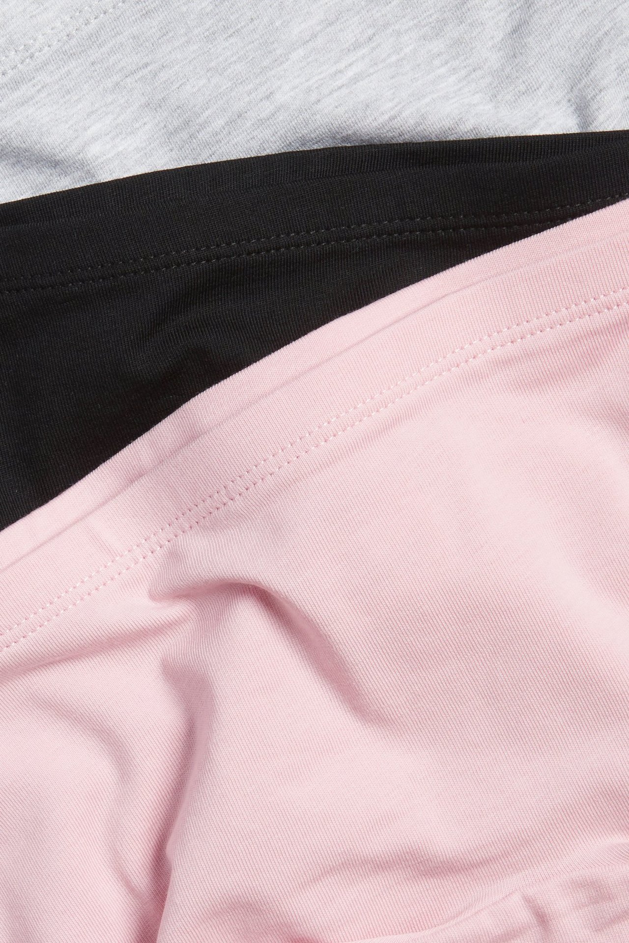 Lähikuva kolmesta yksivärisestä puuvillasekoite-bokserista: vaaleanpunainen, musta ja meleerattu harmaa.