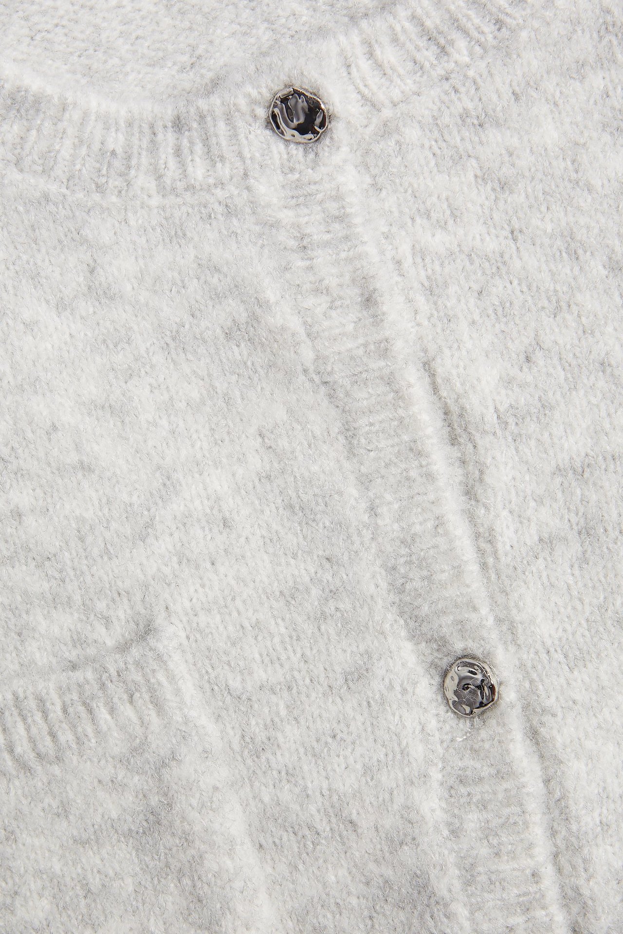 Zbliżenie przodu jasnoszarego melanżowego kardiganu z krótkim rękawem i zaokrąglonymi metalowymi guzikami.