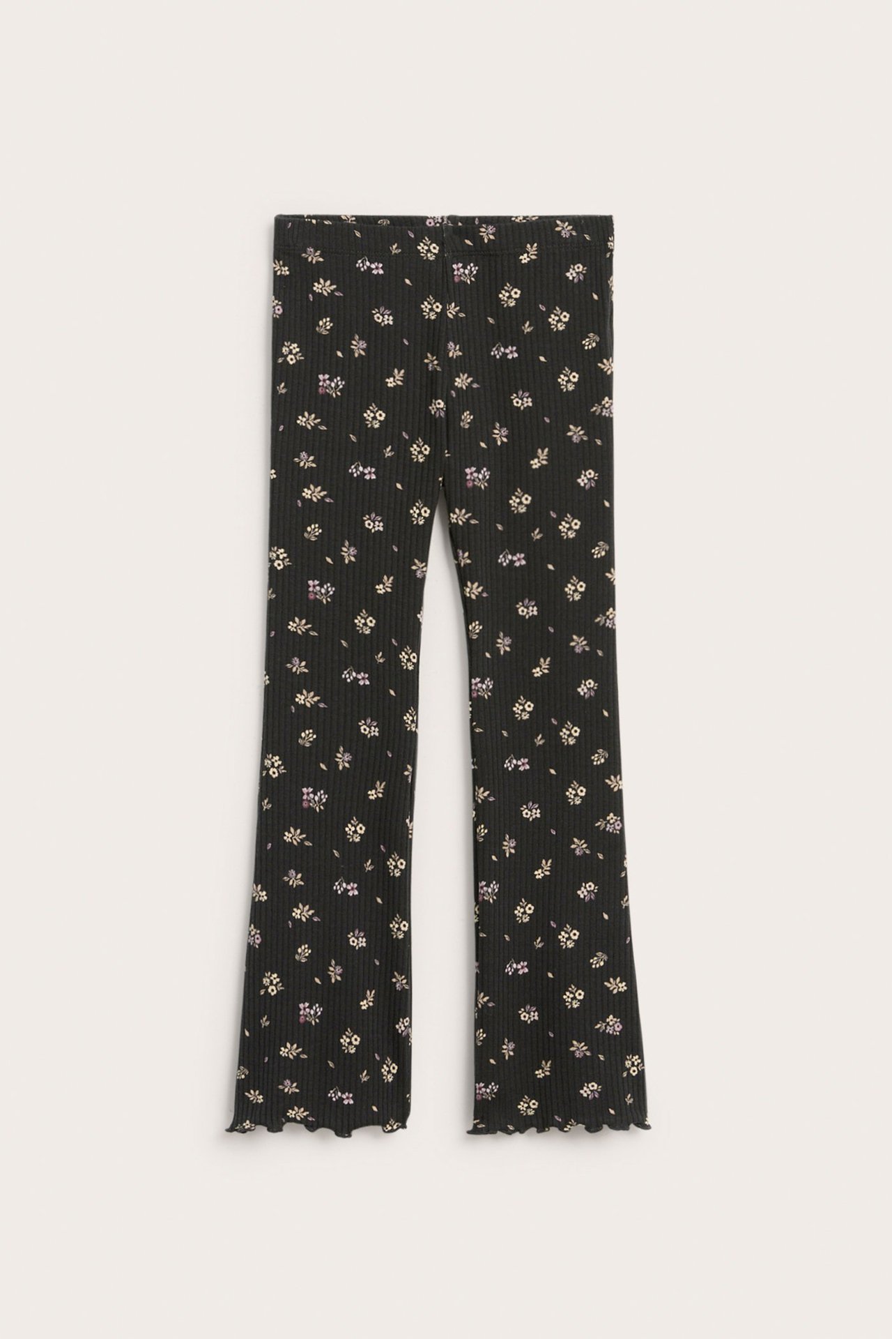 Widok z przodu czarnych prążkowanych legginsów flare z drobnym kwiatowym wzorem i wykończeniem babylock.