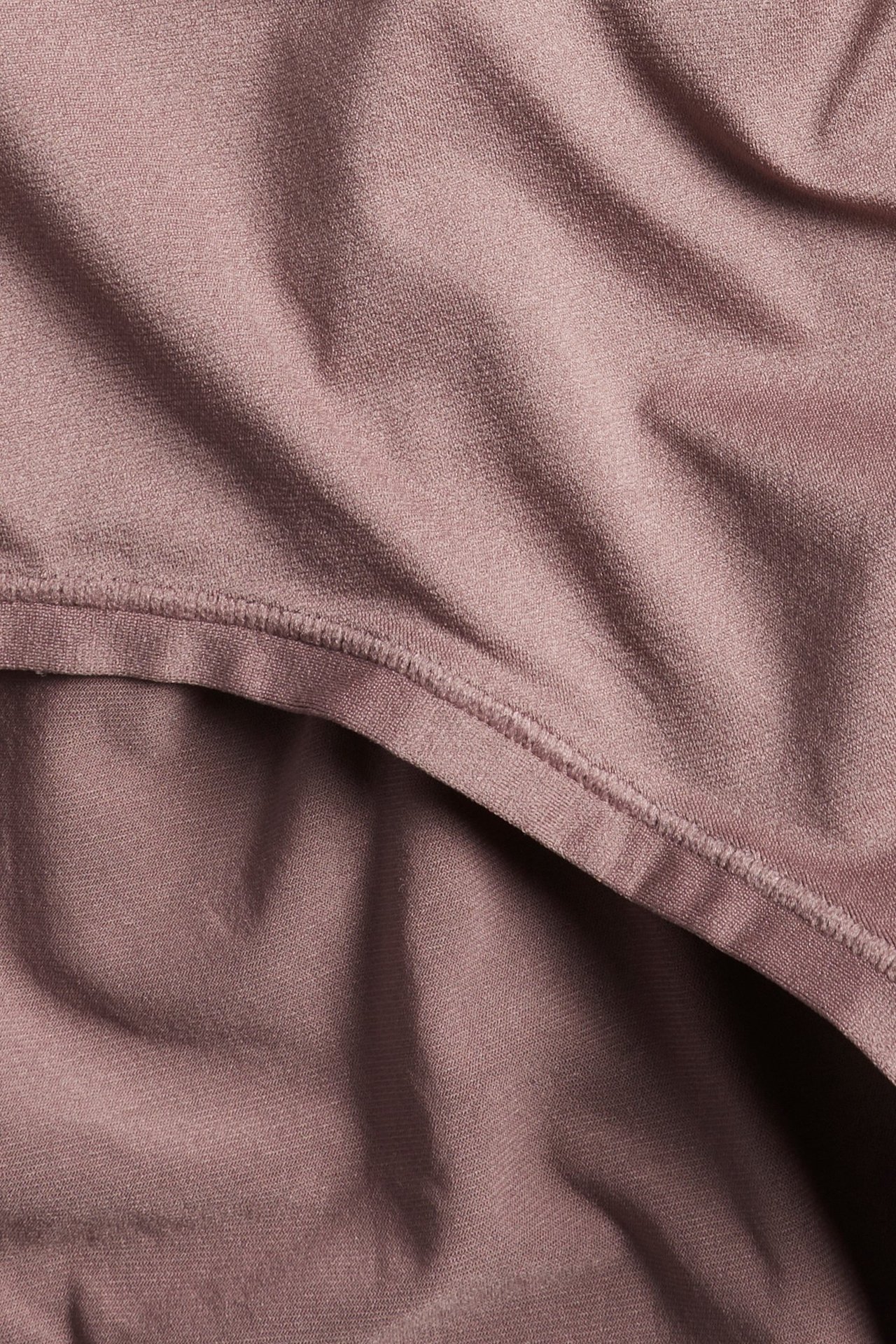 Zbliżenie na ciemnoróżowe figi hipsterskie z wysokim stanem, z miękkiego, elastycznego materiału i widocznymi szwami.