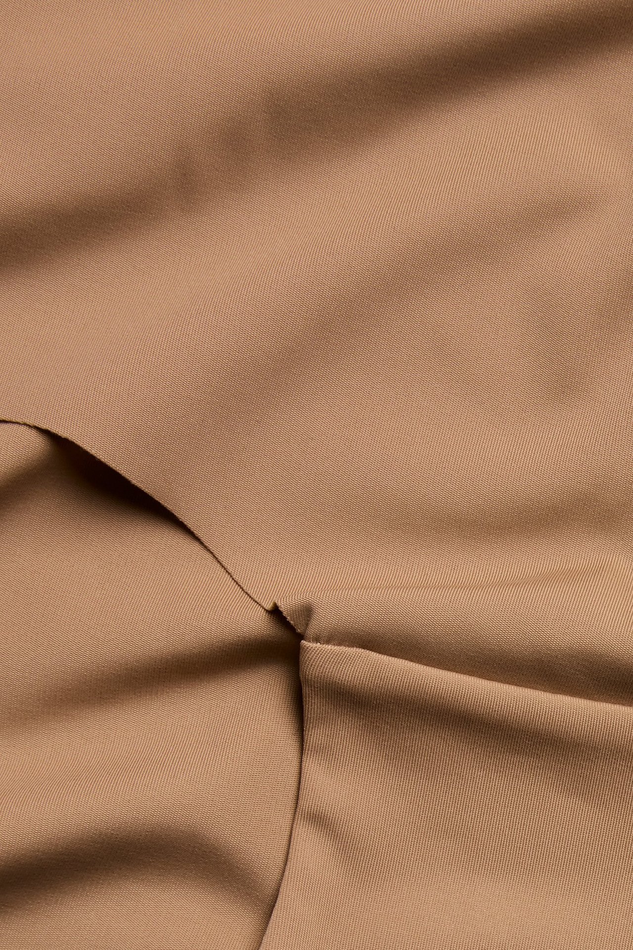 Zbliżenie na brązowe, jednolite figi typu hipster z miękkiej mikrofibry, z zagięciami.