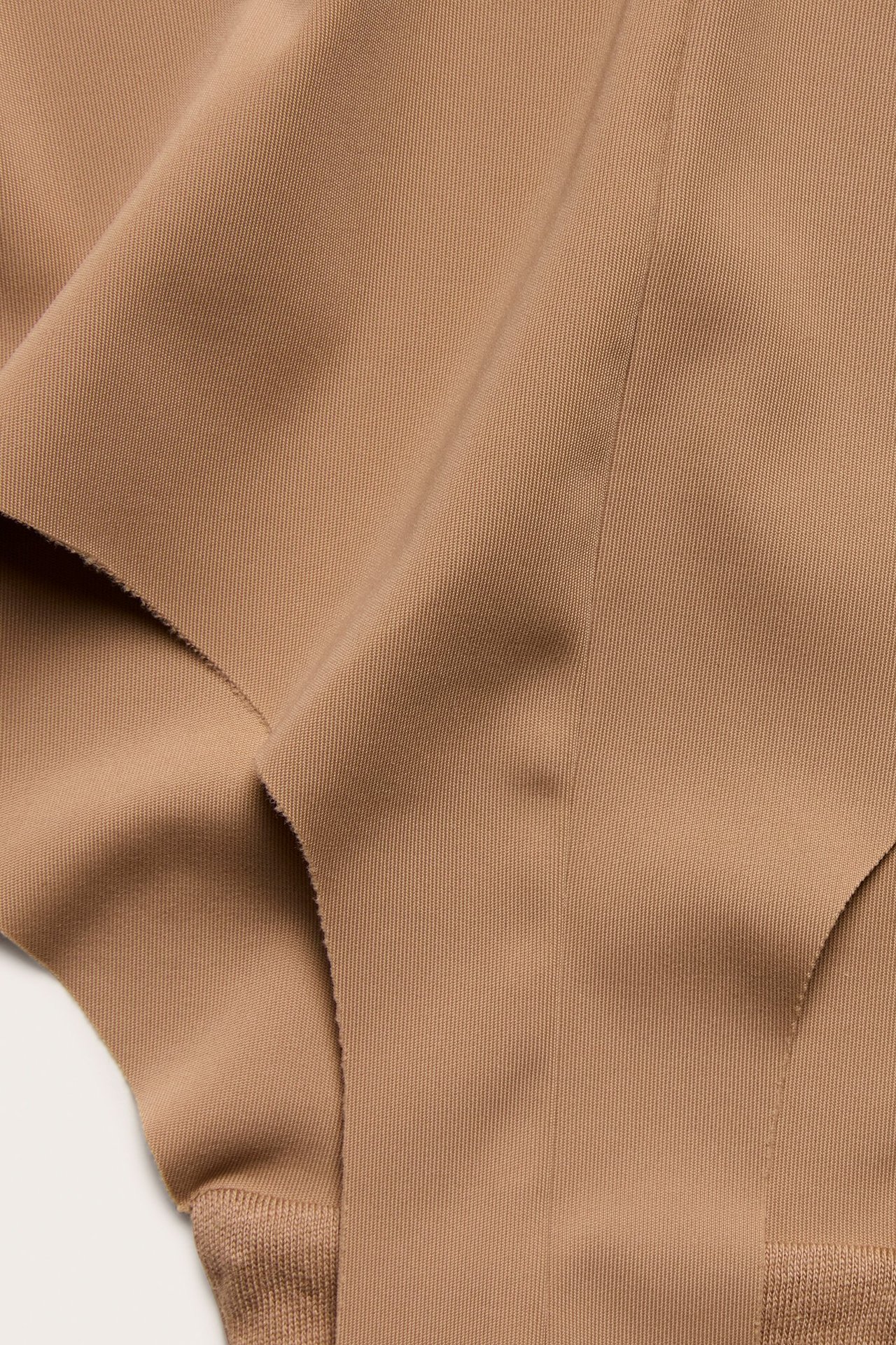 Zbliżenie na brązowe, bezszwowe stringi z gładkiego, elastycznego materiału.