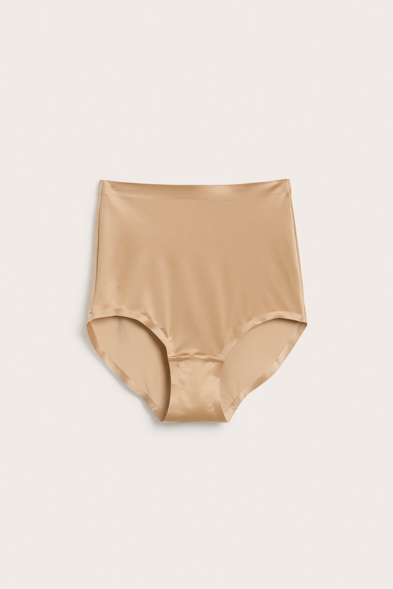 Frontvisning av beige høytlivs shapingtruser i glatt satinmicro med sømløse kanter.