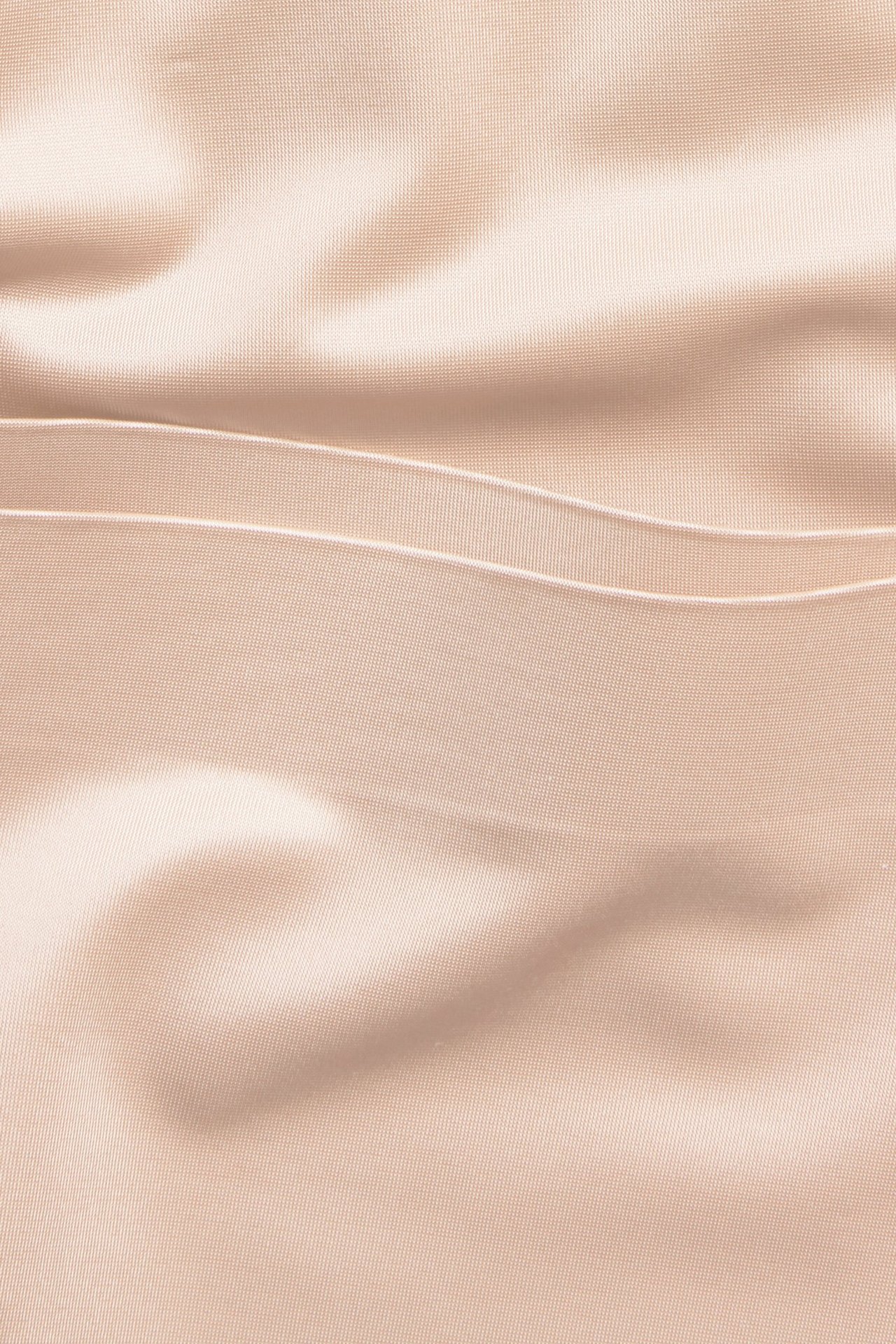 Zbliżenie na jasnoróżowe szorty modelujące z wysokim stanem, z gładkiej satynowej mikrofibry, z bezszwowymi krawędziami.