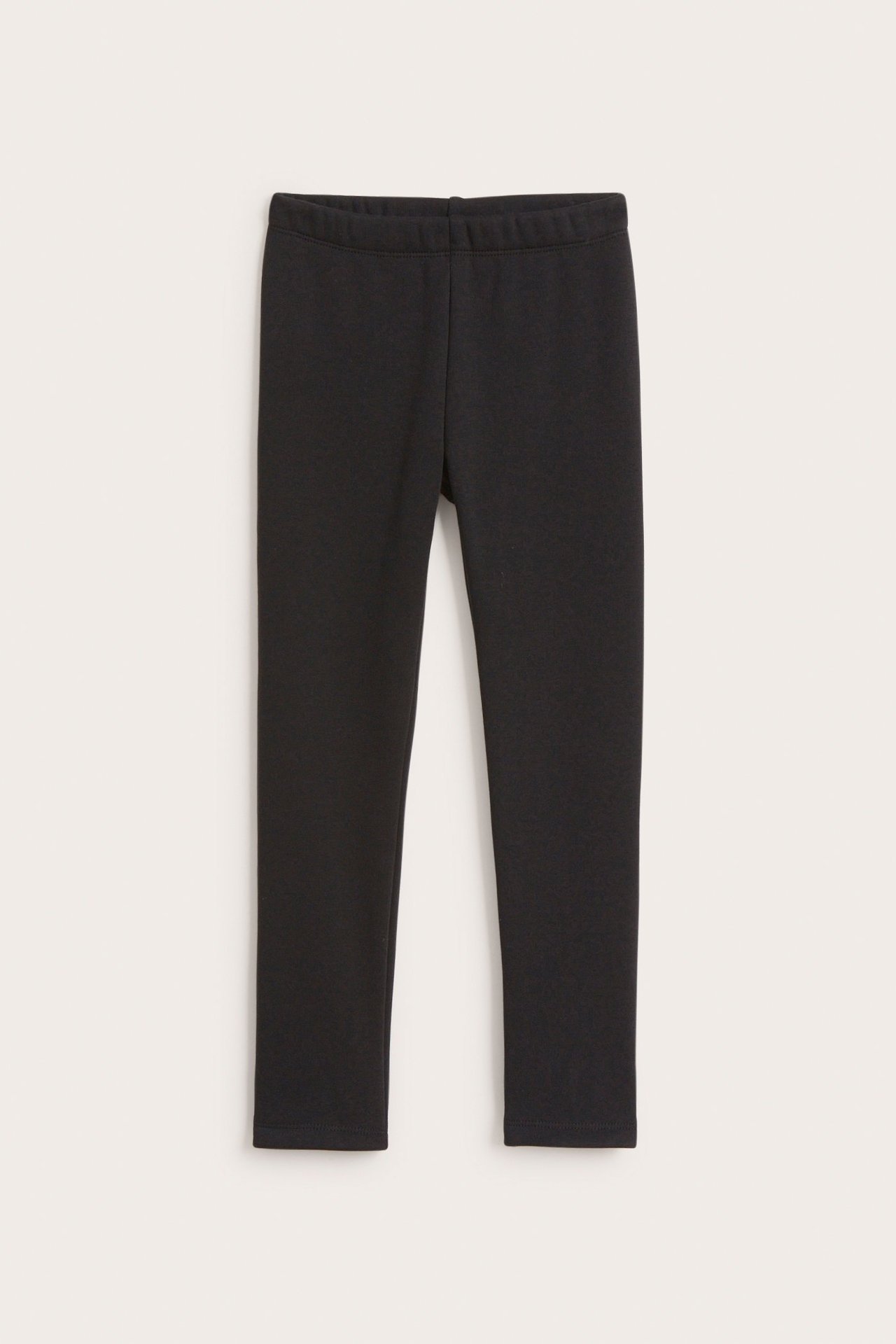 Edestä, yksiväriset mustat lämmittävät leggingsit joustavalla vyötäröllä, litteänä.