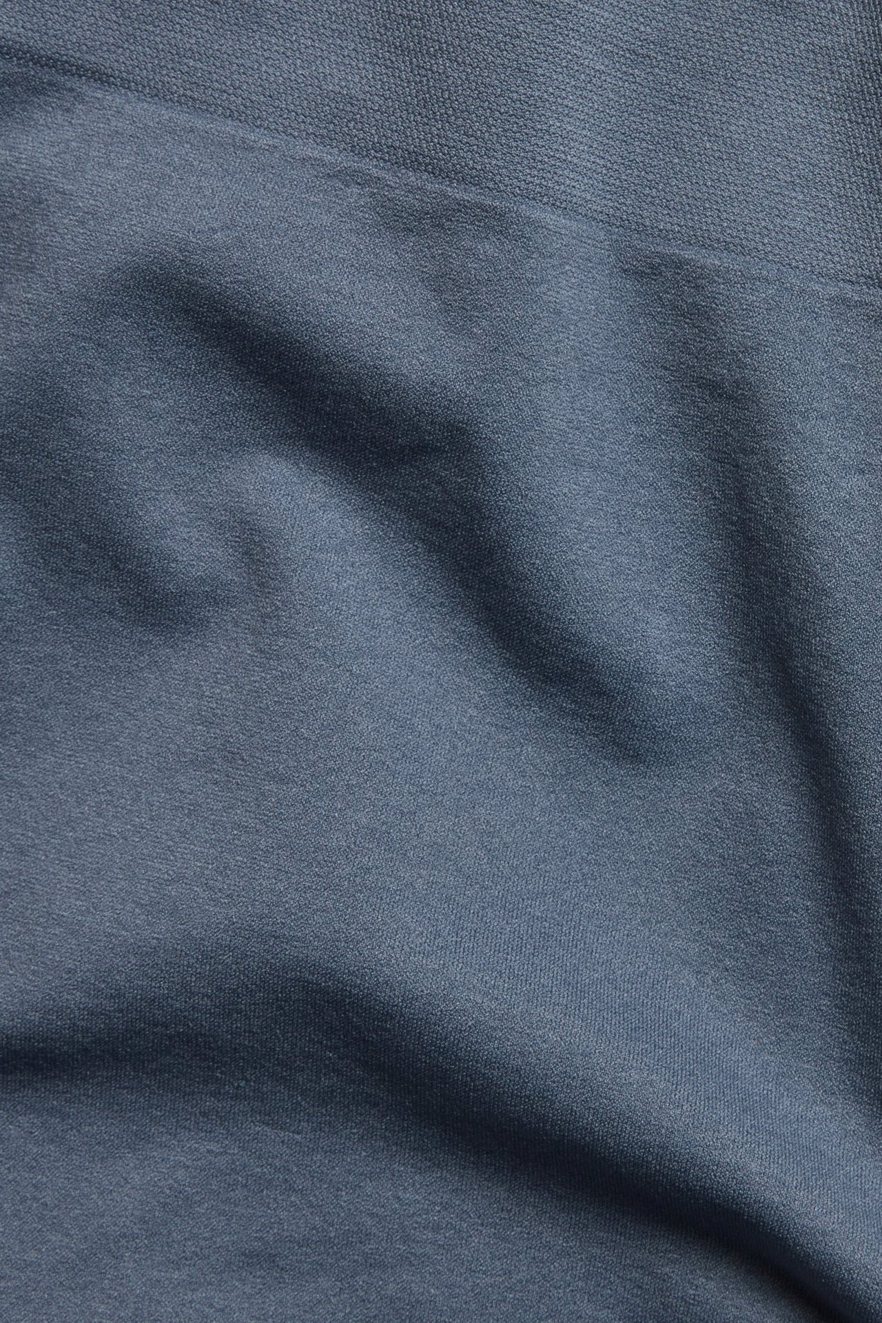 Zbliżenie na ciemnoniebieskie, bezszwowe bokserki z mieszanki poliamidu i elastanu, z widocznym pasem.