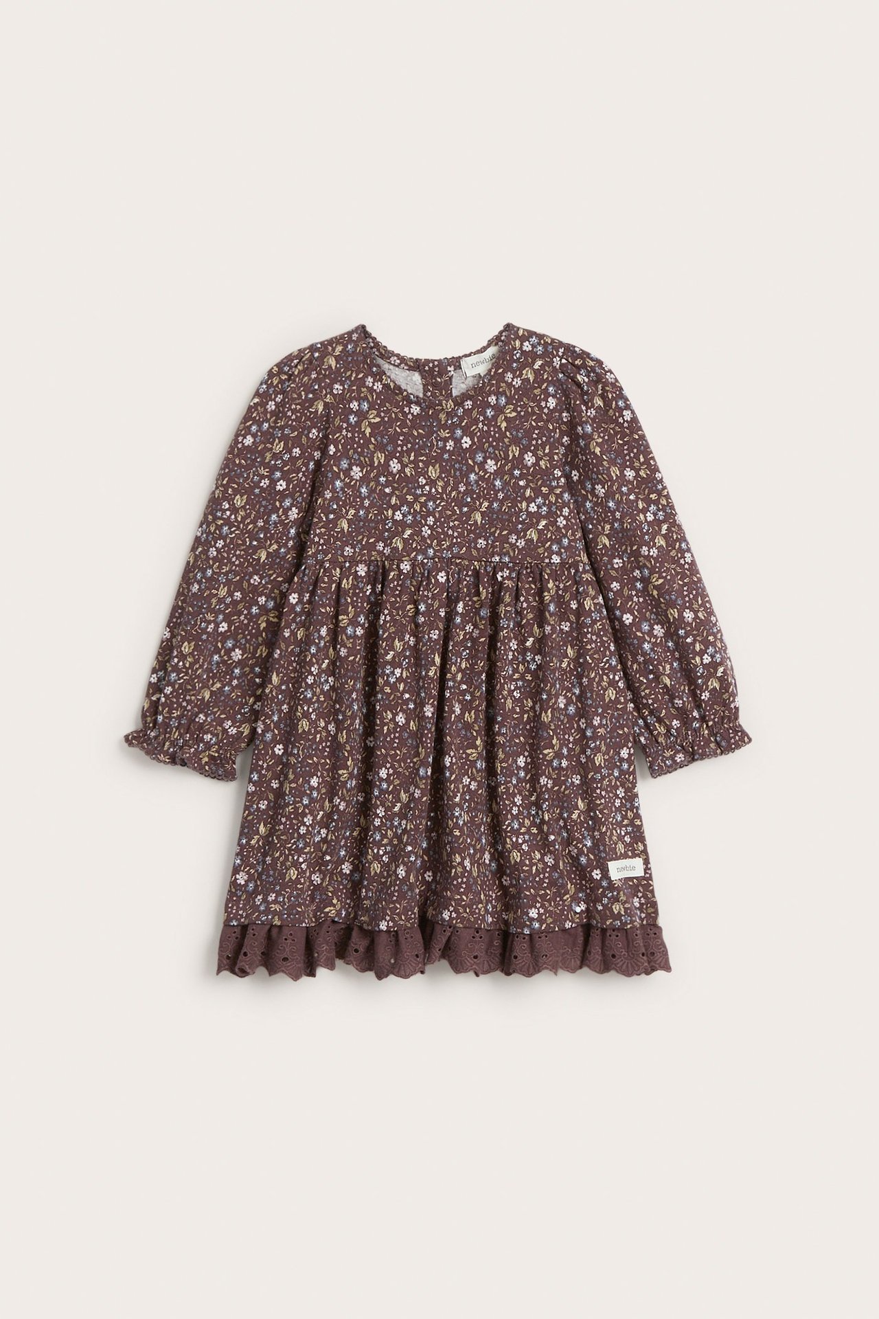 Framifrån: Blommig mörklila jerseyklänning för barn med puffärmar och spetskant i fållen.