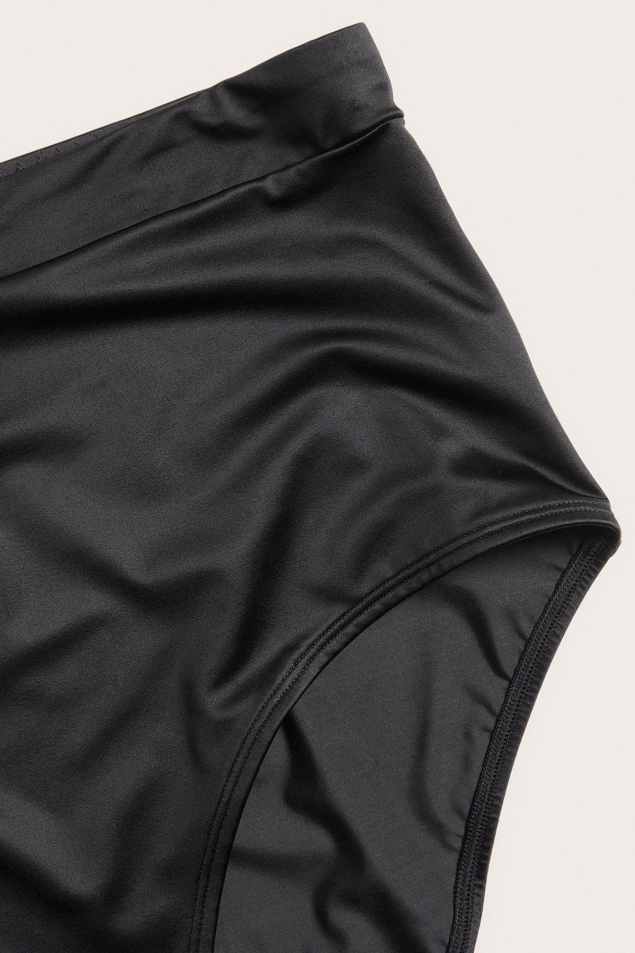 Zbliżenie czarnych, wysokich fig z błyszczącą powierzchnią i elastycznym pasem.