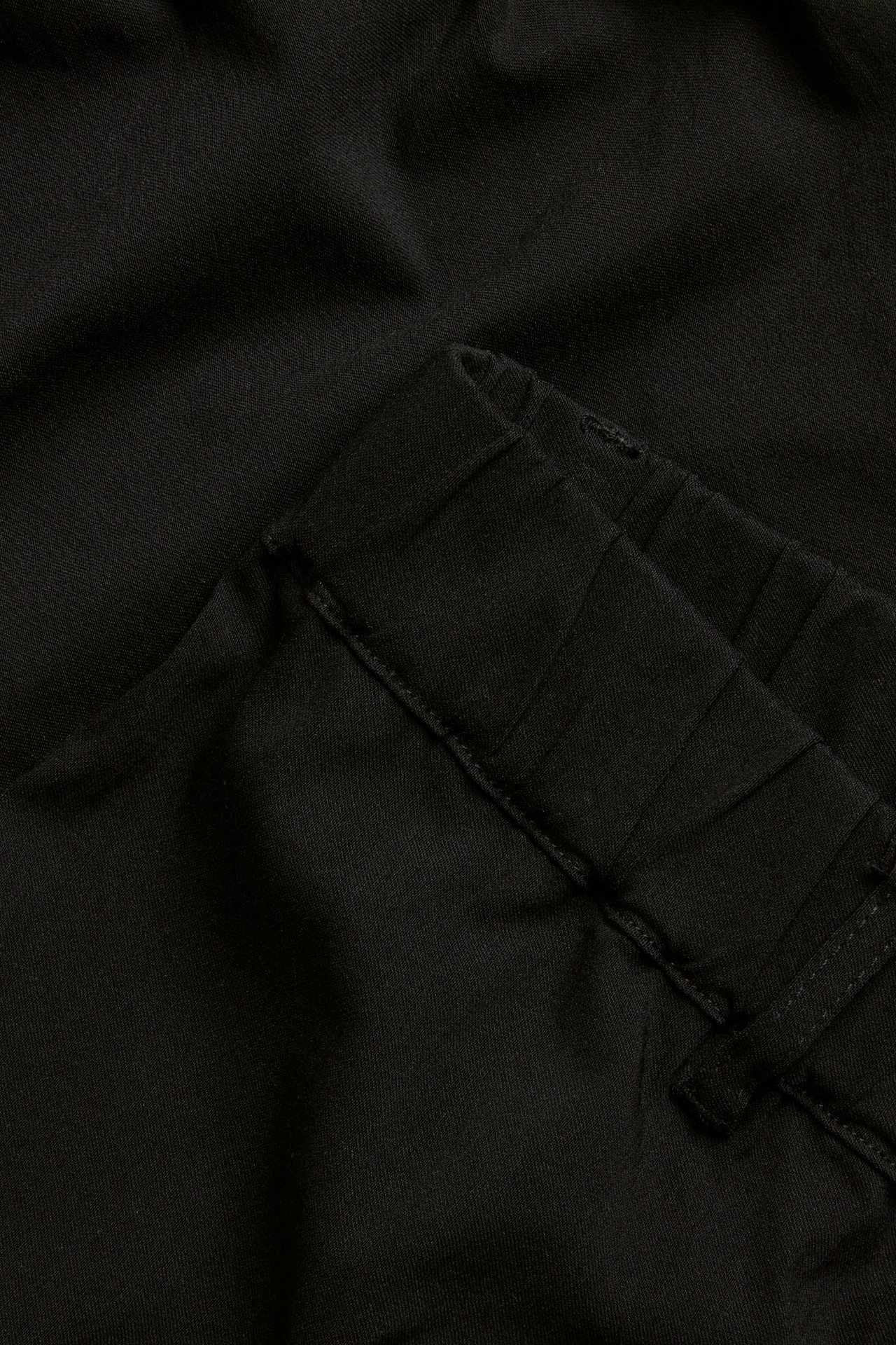 Zbliżenie na czarne tregginsy z mieszanki wiskozy, pokazujące pas ze szlufkami.