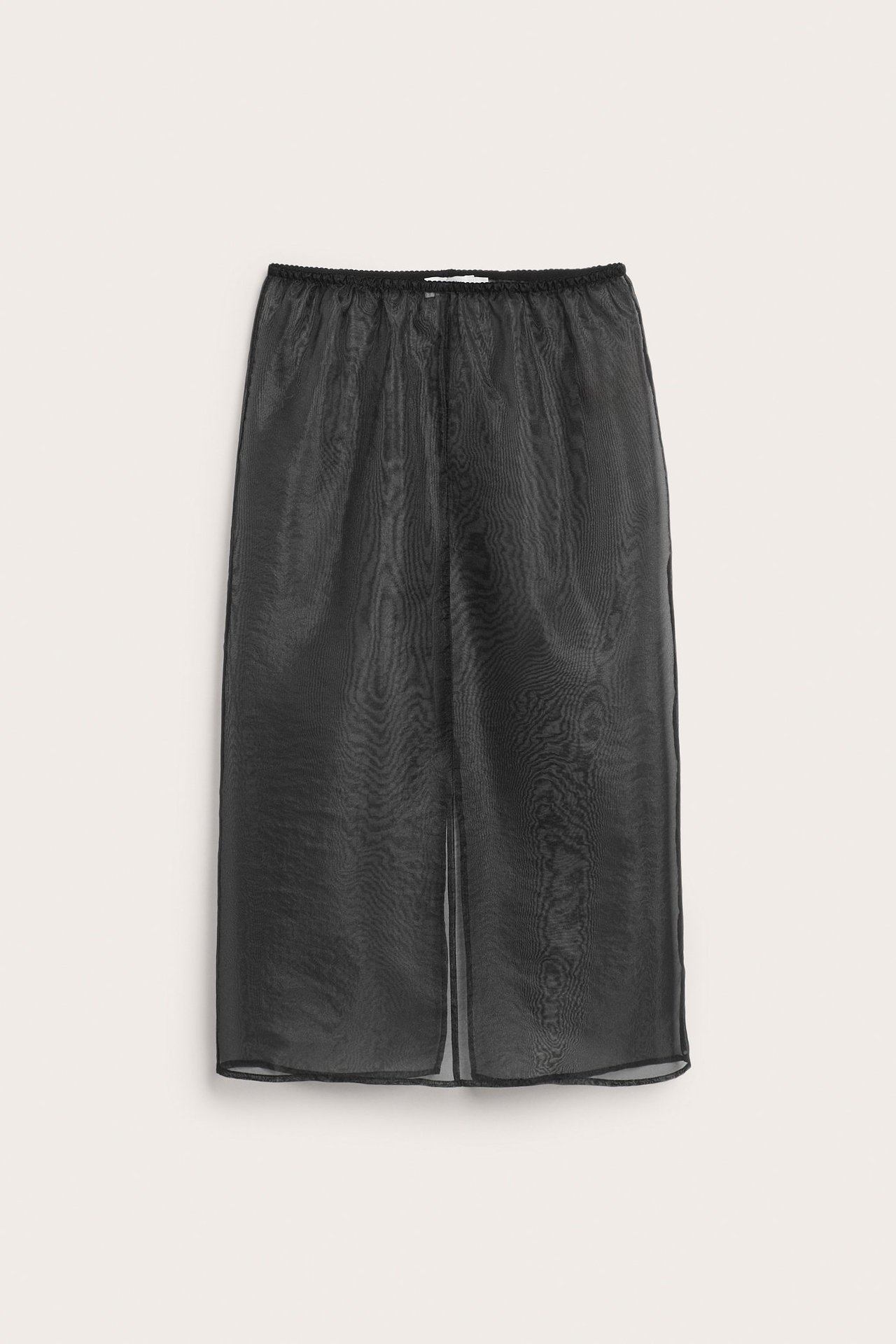 Frontvy av en svart transparent organzakjol i midilängd med resår i midjan.