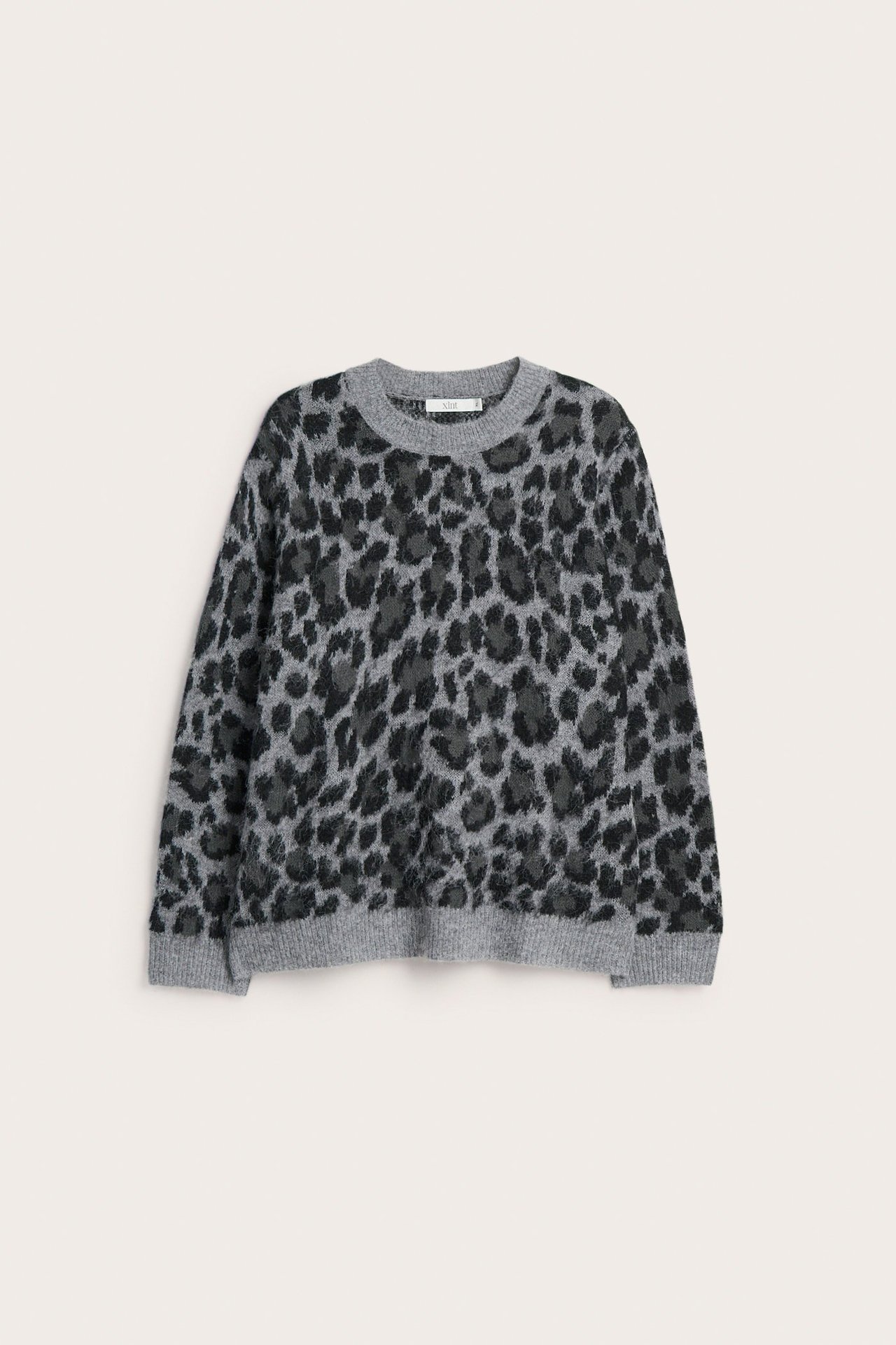 Edestä: harmaameleerattu jacquardneulepusero tummanharmaalla leopardikuviolla.