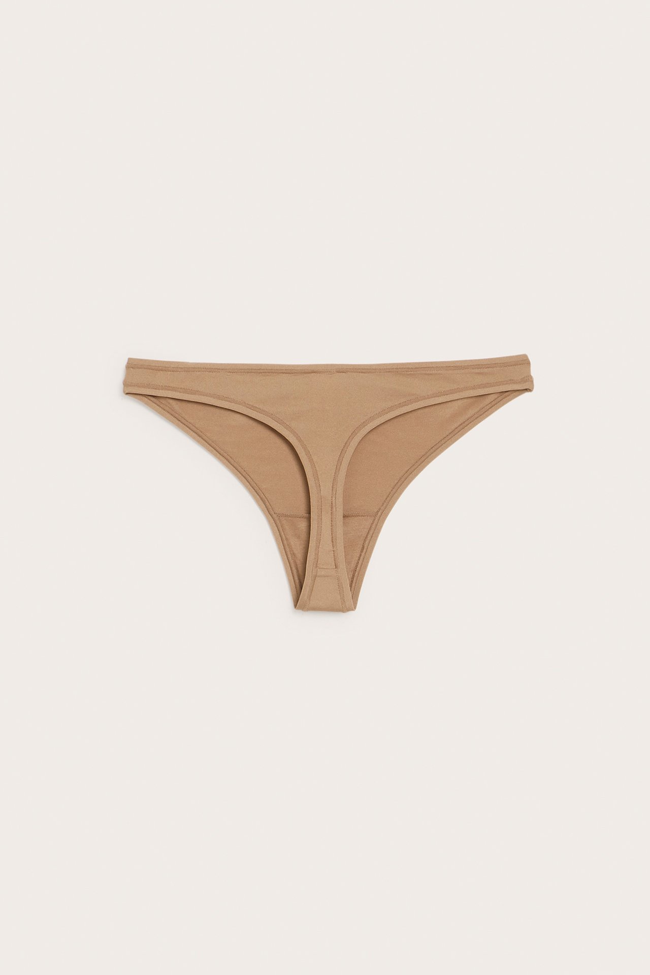 Frontvy av en enfärgad brun tunn stringtrosa för dam i mjukt, stretchigt material.