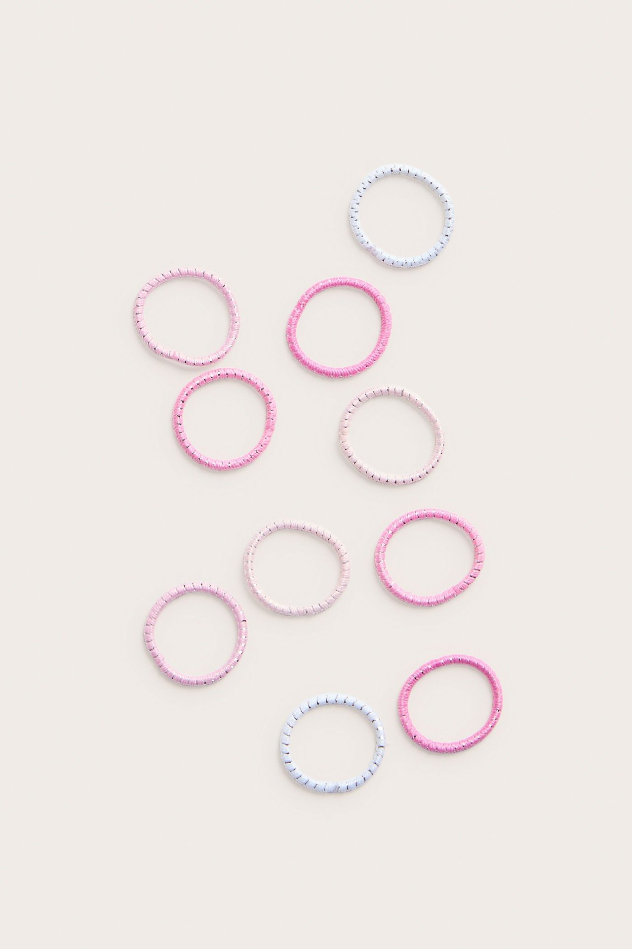 Ylhäältä kuvattu kymmenen polyamidi hiuslenkkiä vaaleanpunaisena, vaaleanlilana ja vaaleansinisenä.