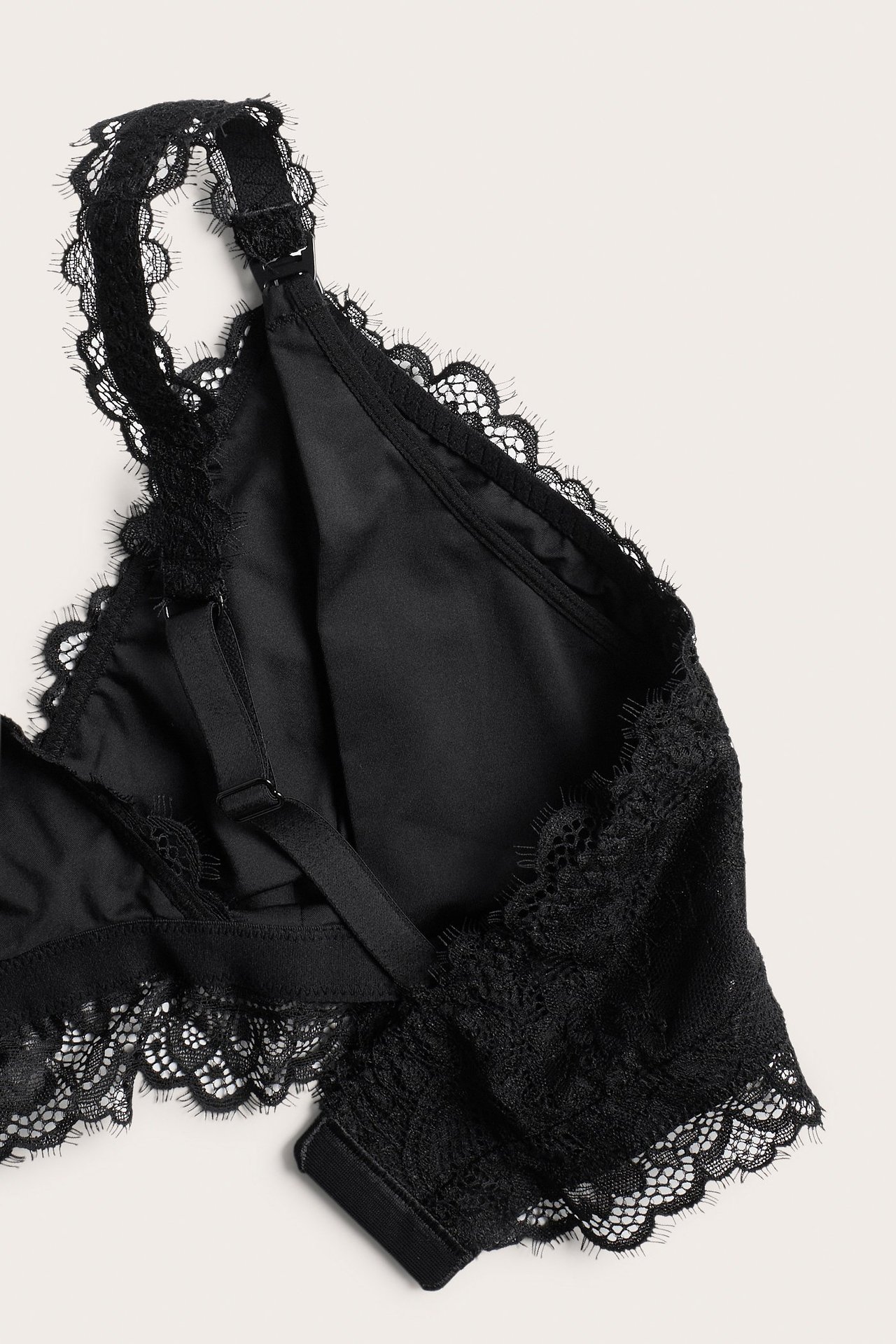 Zbliżenie czarnego koronkowego biustonosza do karmienia z regulowanymi ramiączkami i zapięciem.