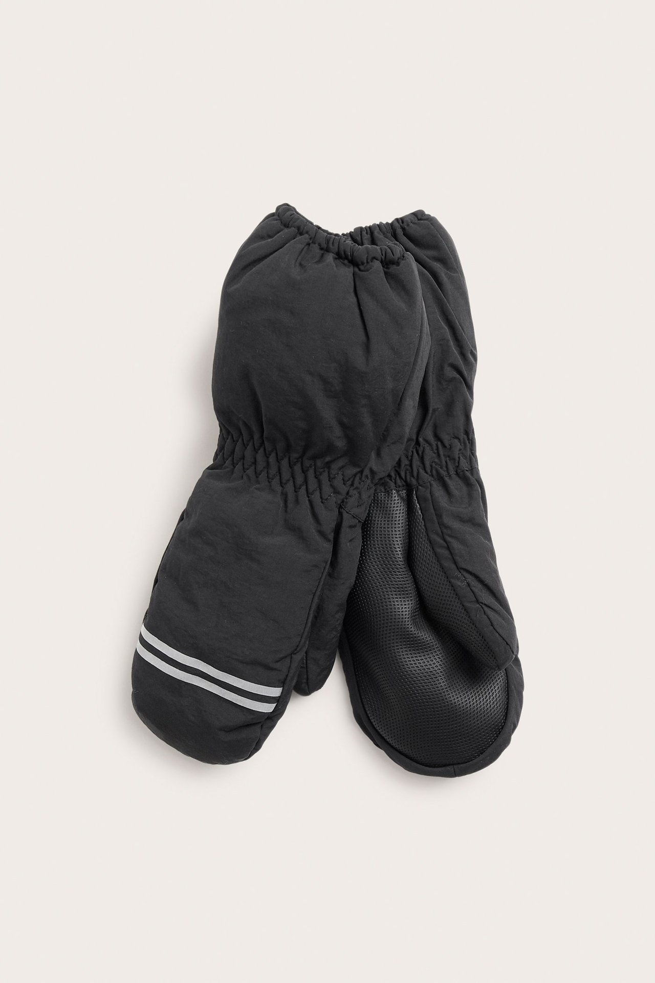 Widok z przodu dwóch czarnych rękawiczek dziecięcych z elastycznymi nadgarstkami, teksturowanymi dłońmi i odblaskami.