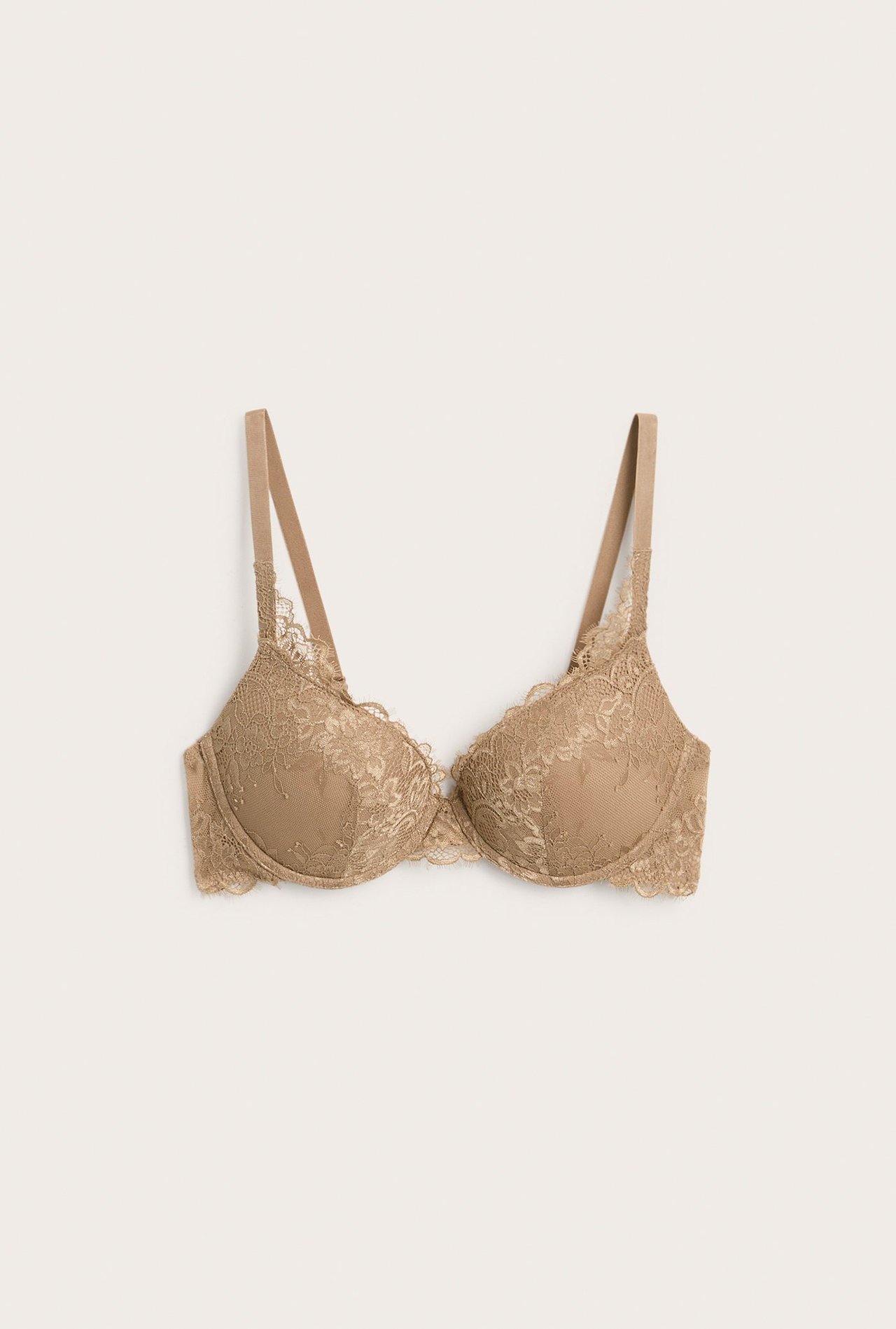 Frontvy av en beige spetsklädd push up-bh med justerbara axelband och ögonfransspets.