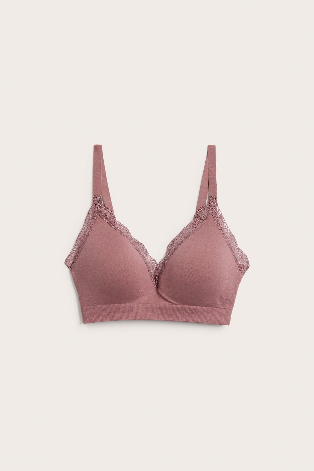 Framifrån, en mauve sömlös bygellös BH med formpressade kupor och spetsdetaljer.
