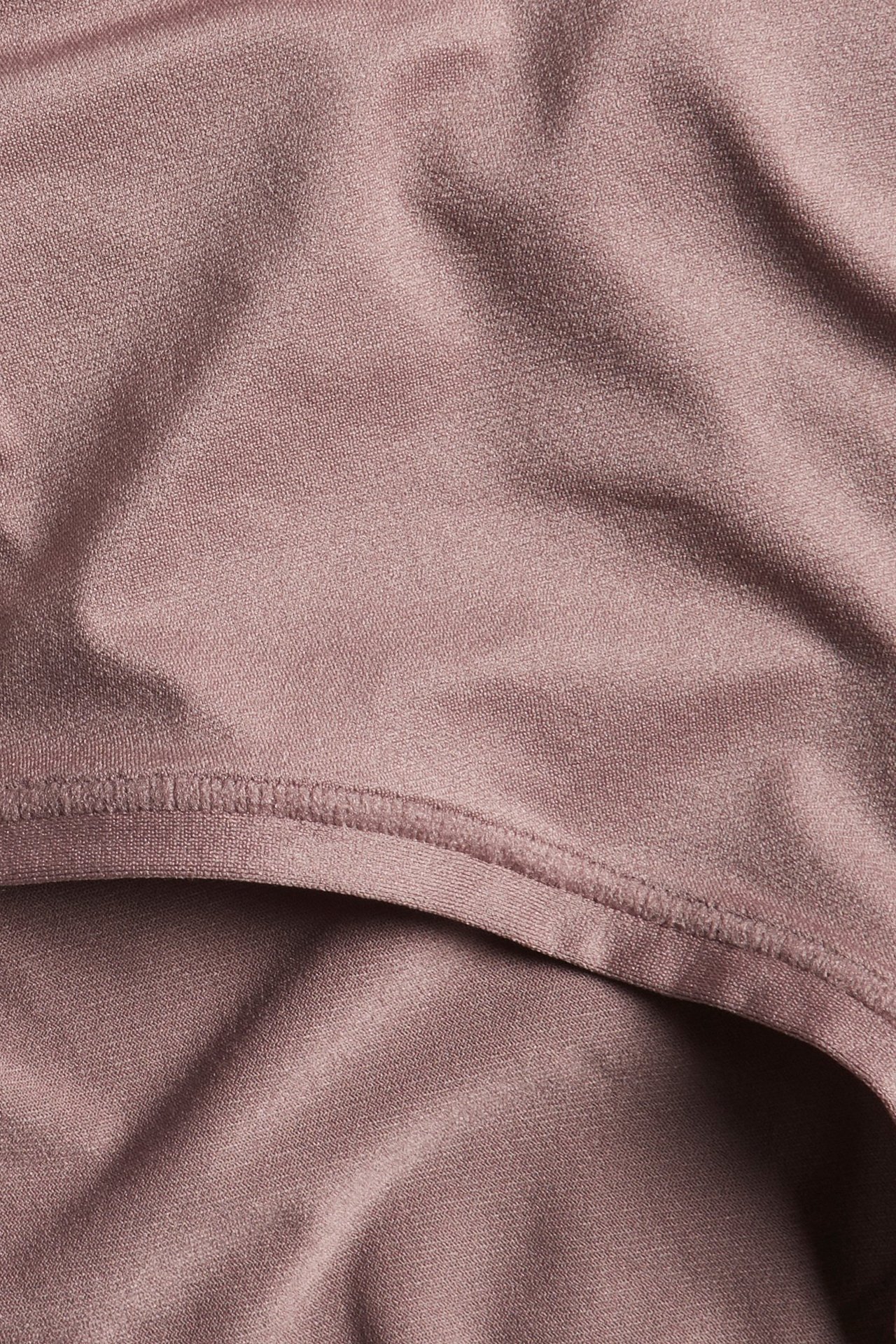 Zbliżenie na ciemnoróżowe damskie stringi, ukazujące miękki, elastyczny materiał i płaski szew.