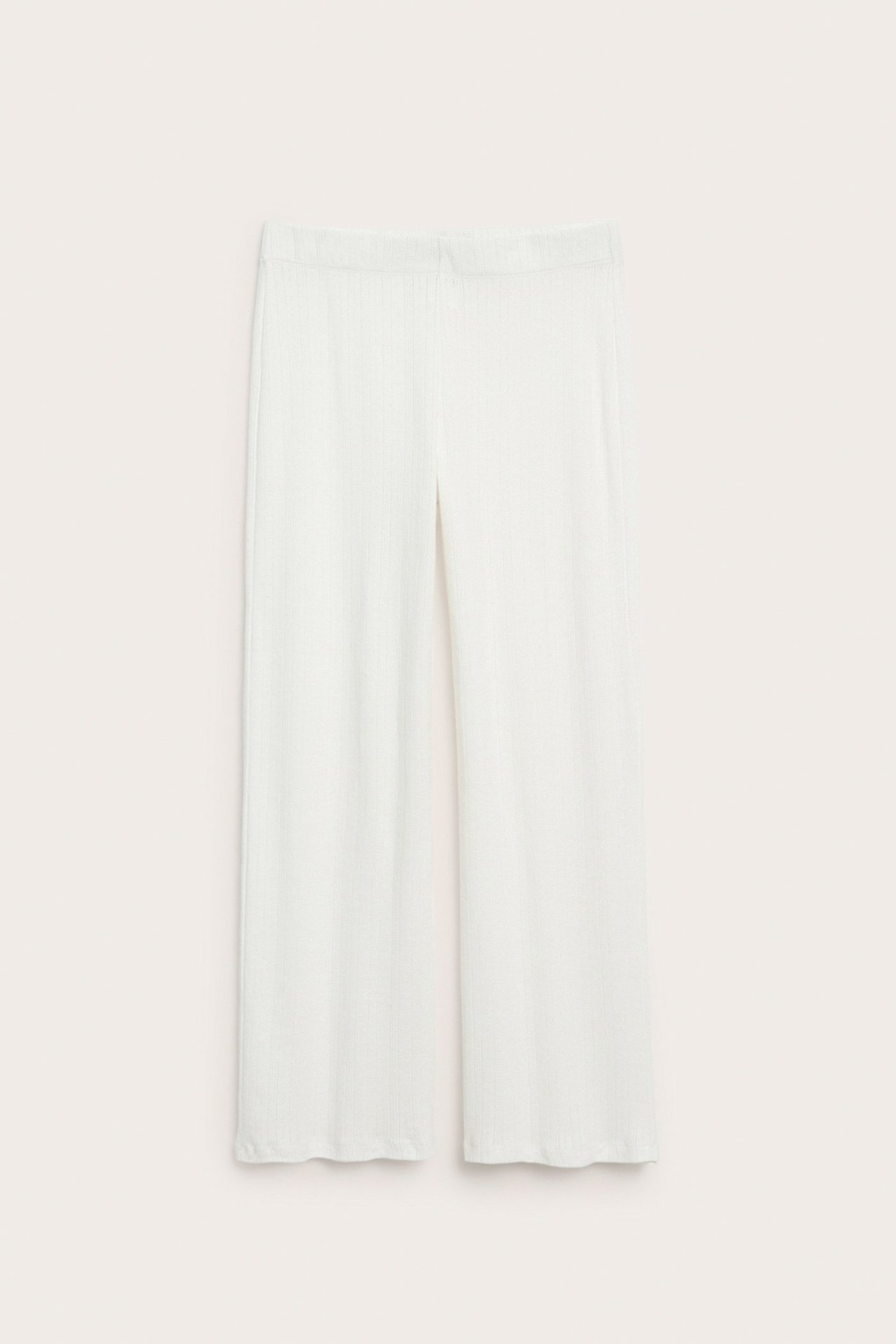Frontvisning av hvite, fint ribbestrikkede, vide pyjamasbukser i bomull med elastisk midje.