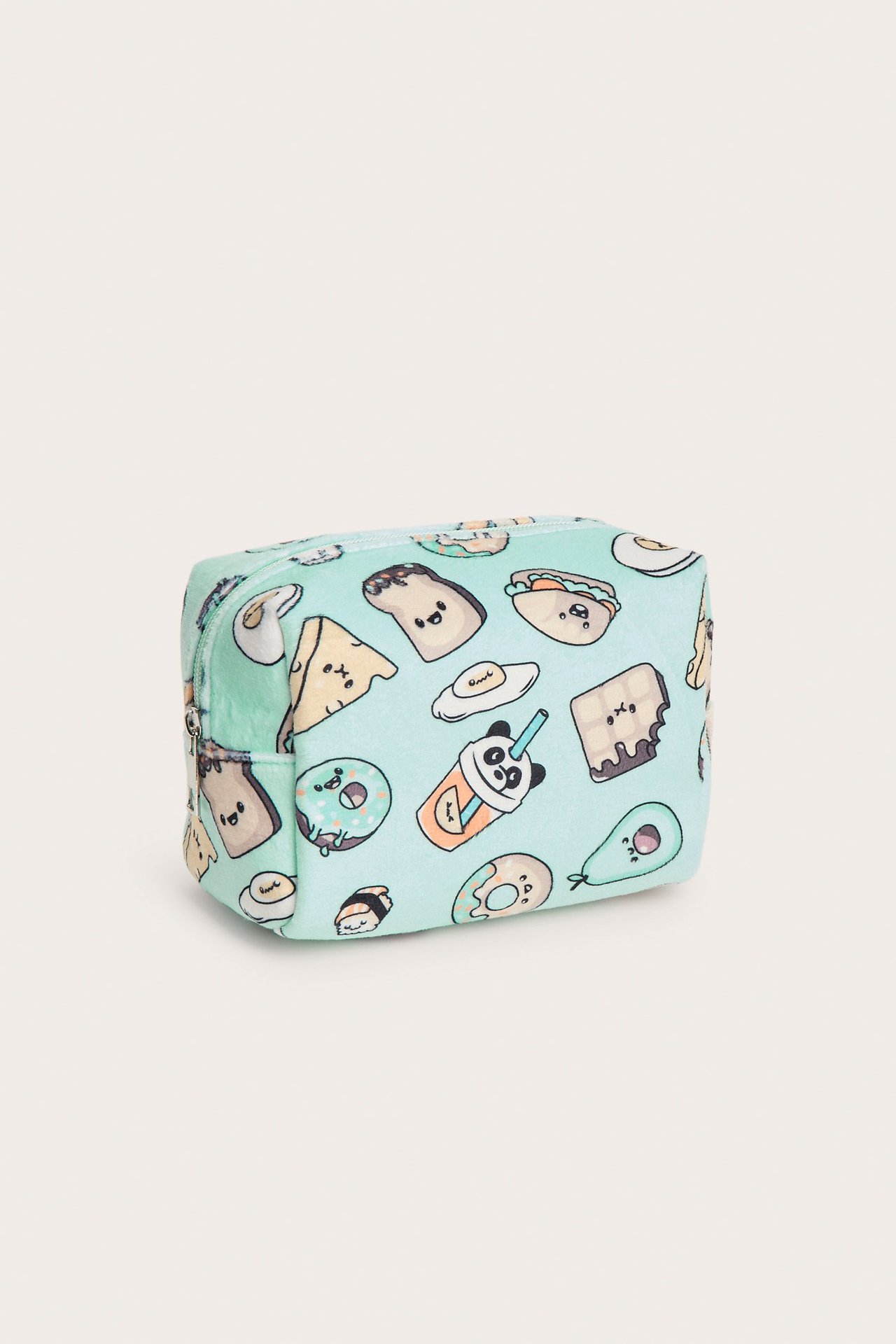 Edestä näkymä vaaleansinisestä veluurisesta toilettilaukusta, jossa on hauska ruoka-aiheinen kuvio.