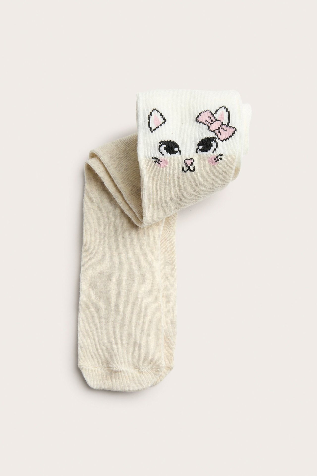 Widok z góry na ecru rajstopy dziecięce z aplikacją kociej twarzy i różową kokardą na kolanie.
